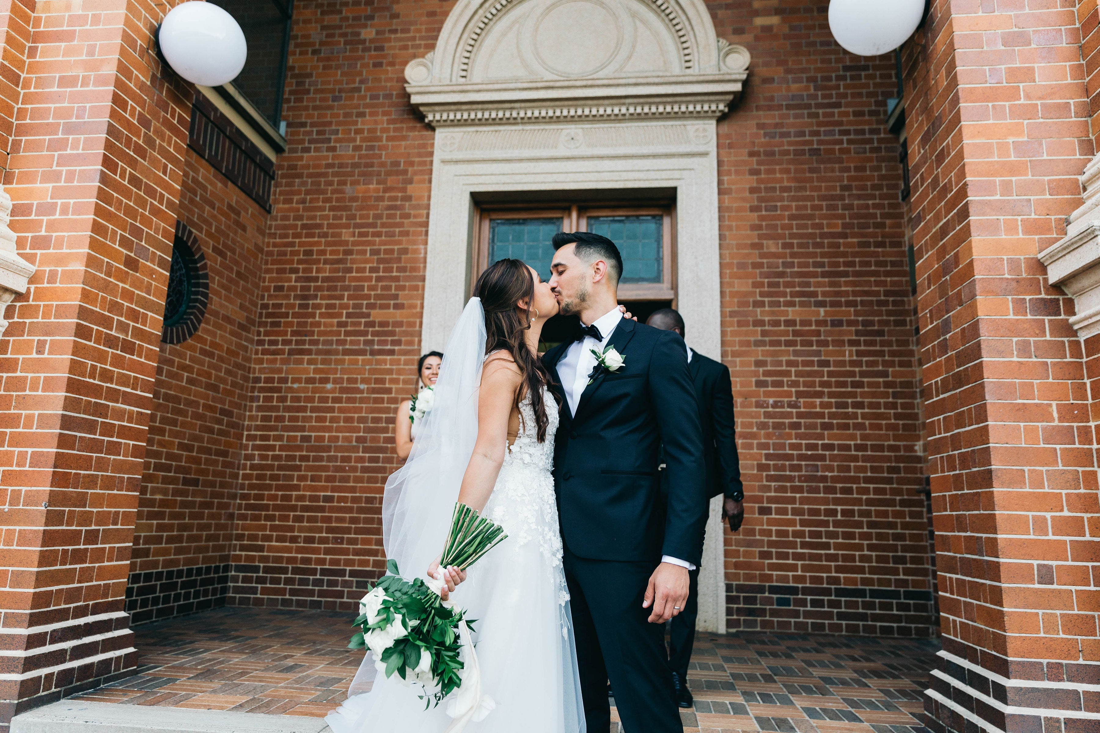 Bride and groom kiss in front of church wedding in Brisbane