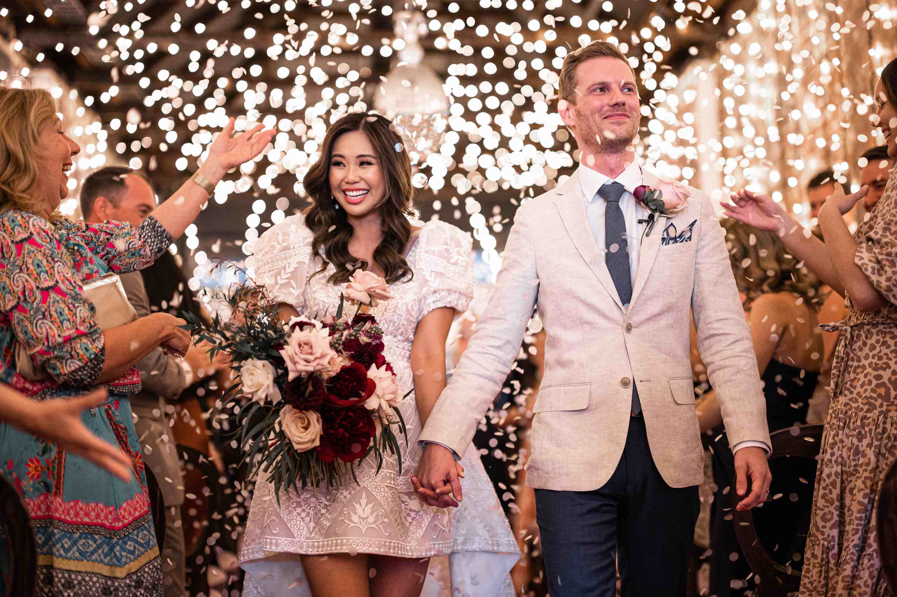 bride and groom being showered with confetti by guests at their wedding