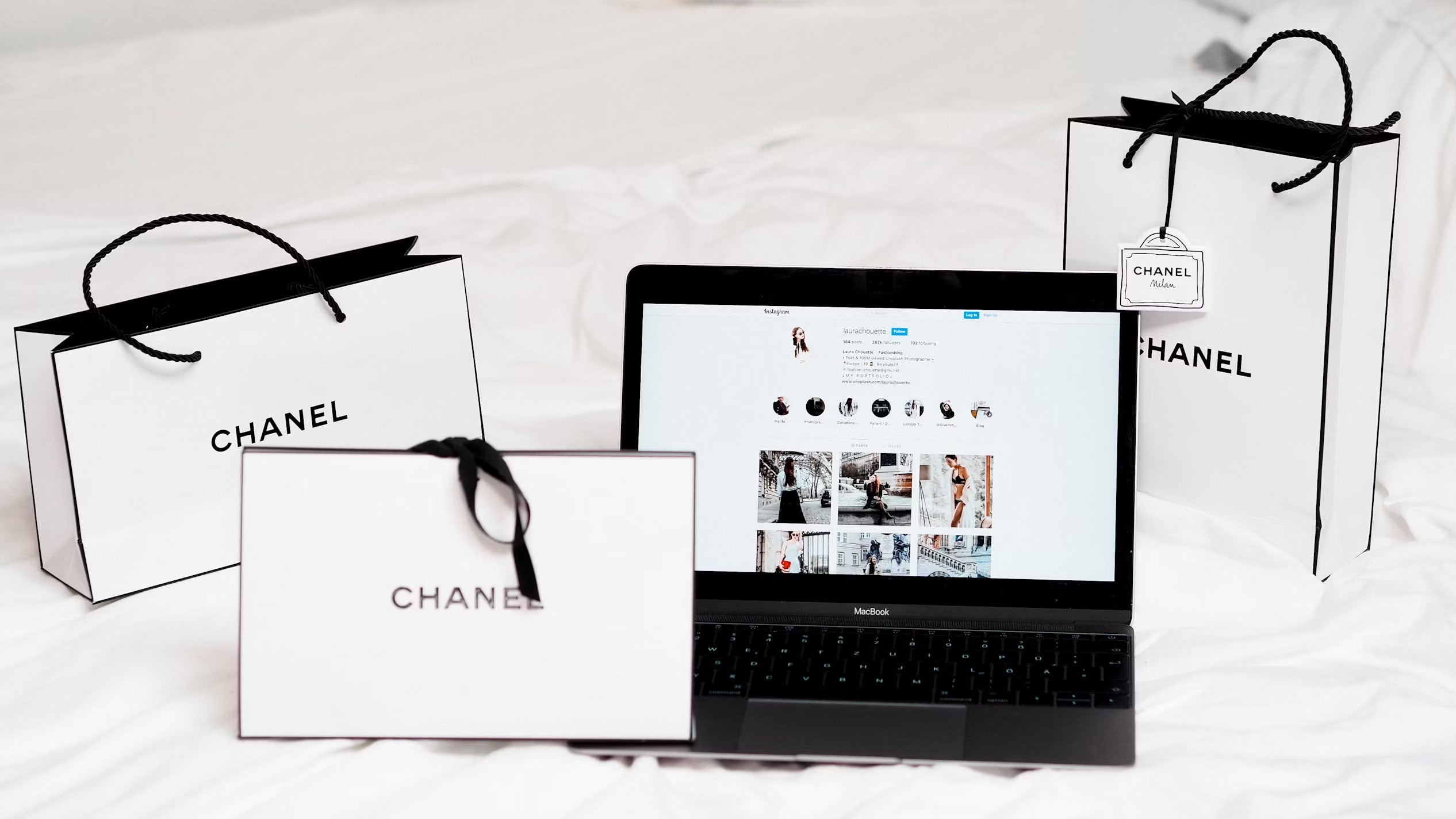 chanel bags beside laptop