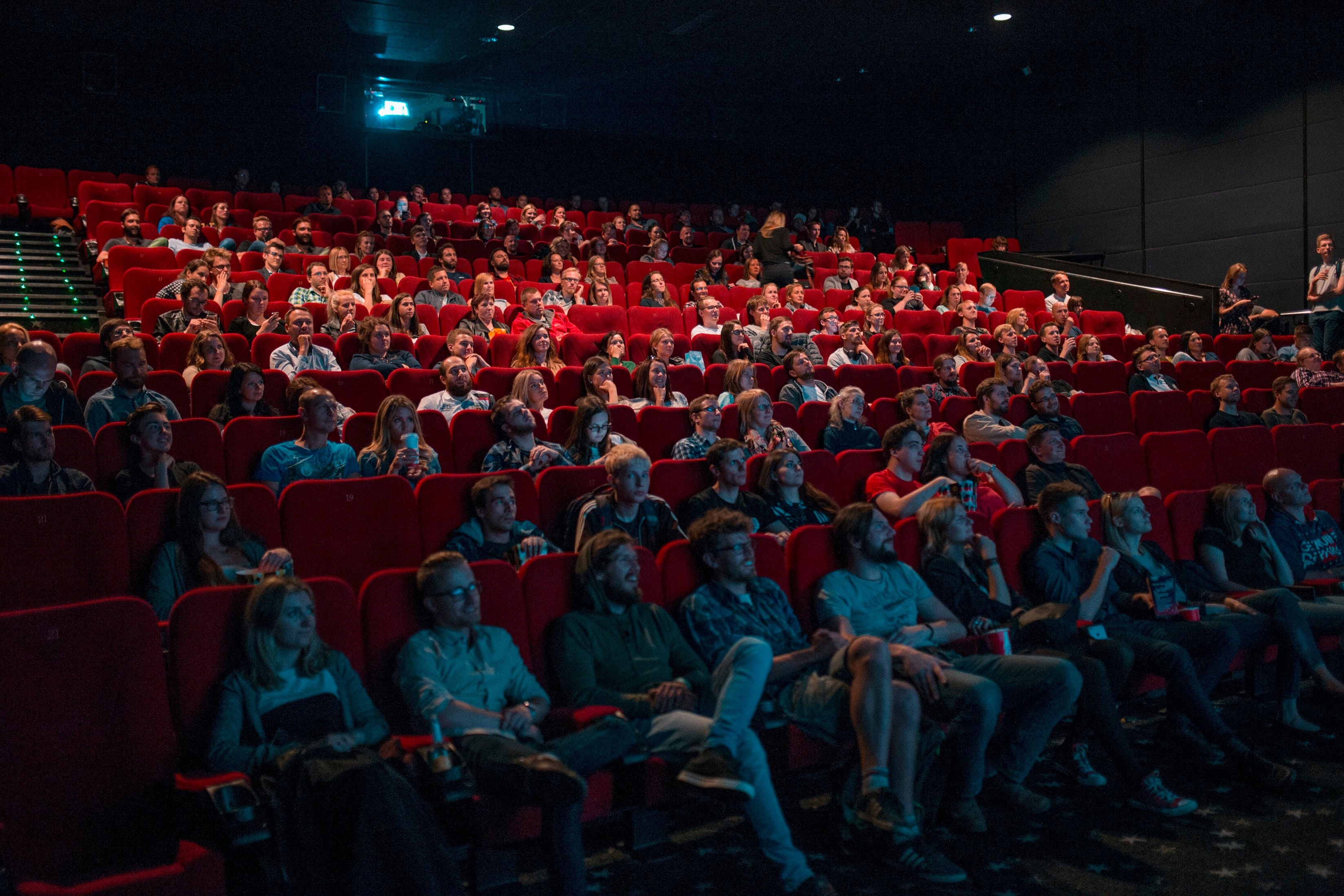 movie theatre full of people in red seats