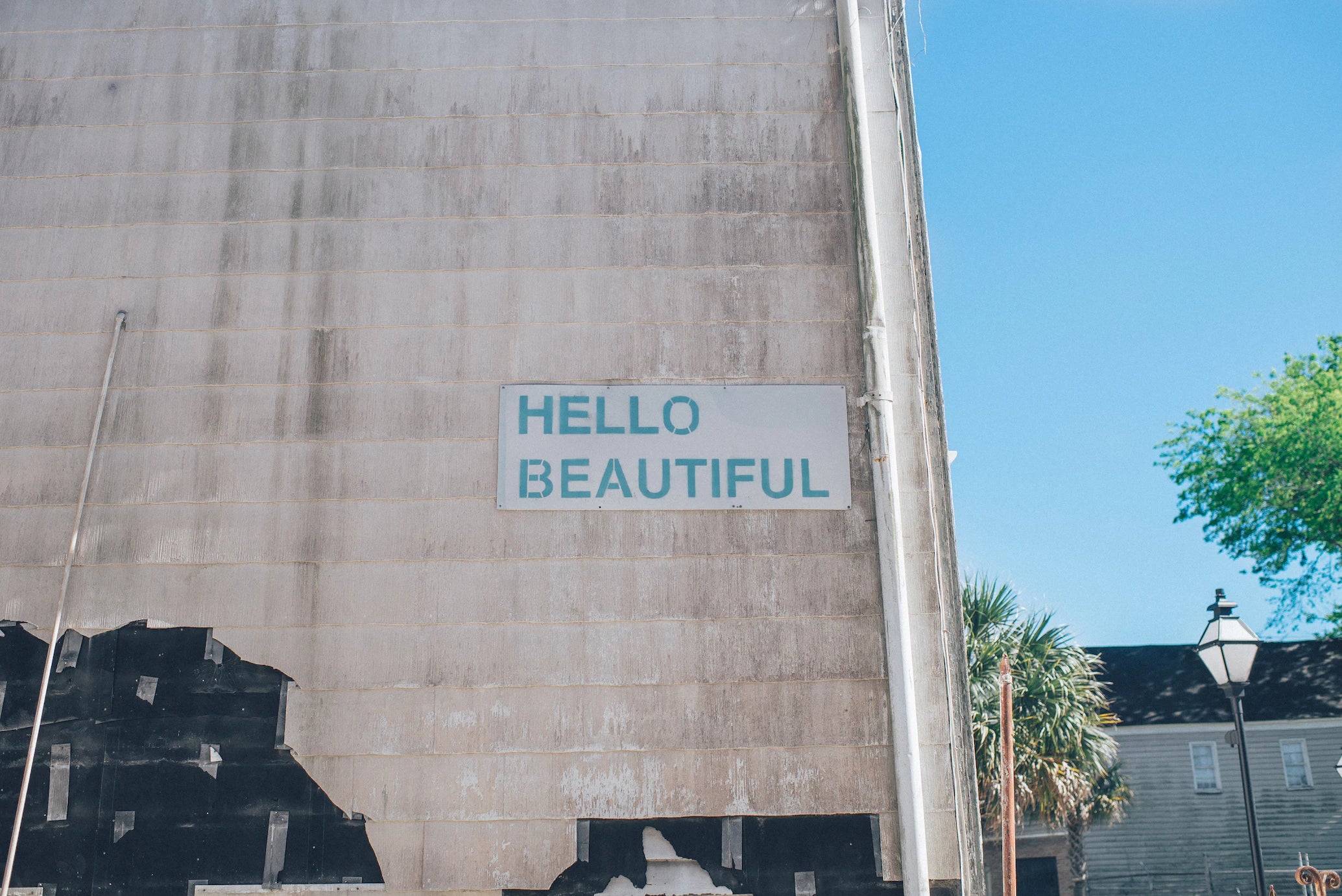 sign saying hello beautiful on brick wall