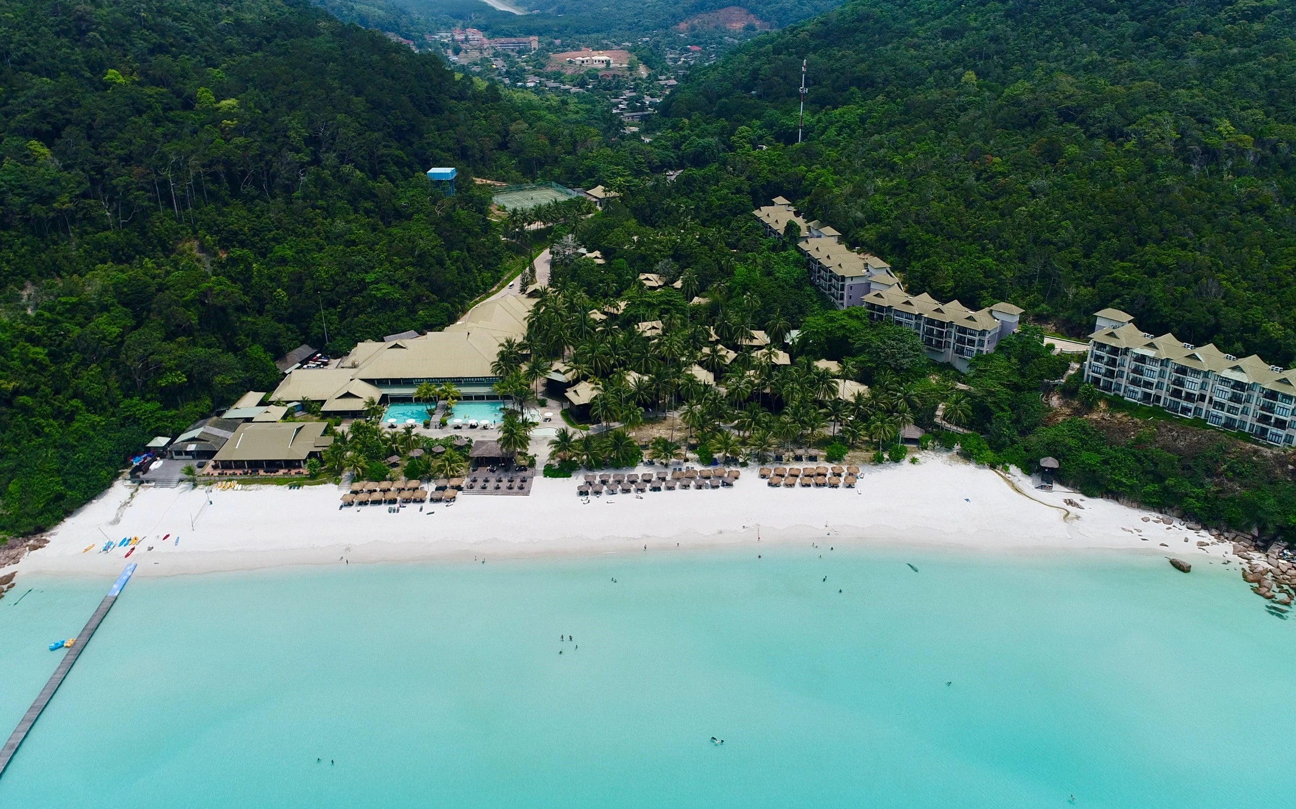 tropical island resort with beach surrounded by trees and penthouses