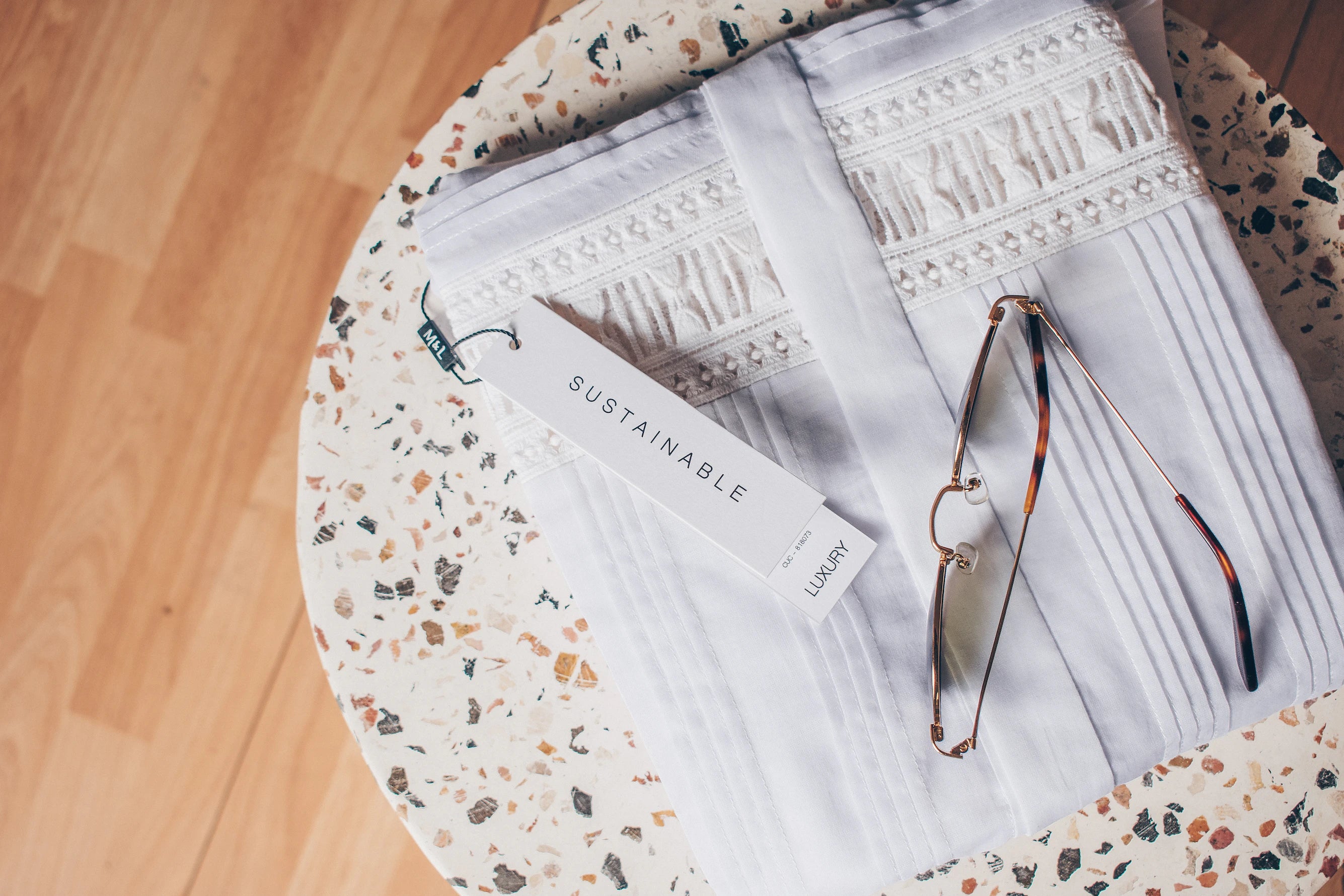 white garment on marble table top with spectacles