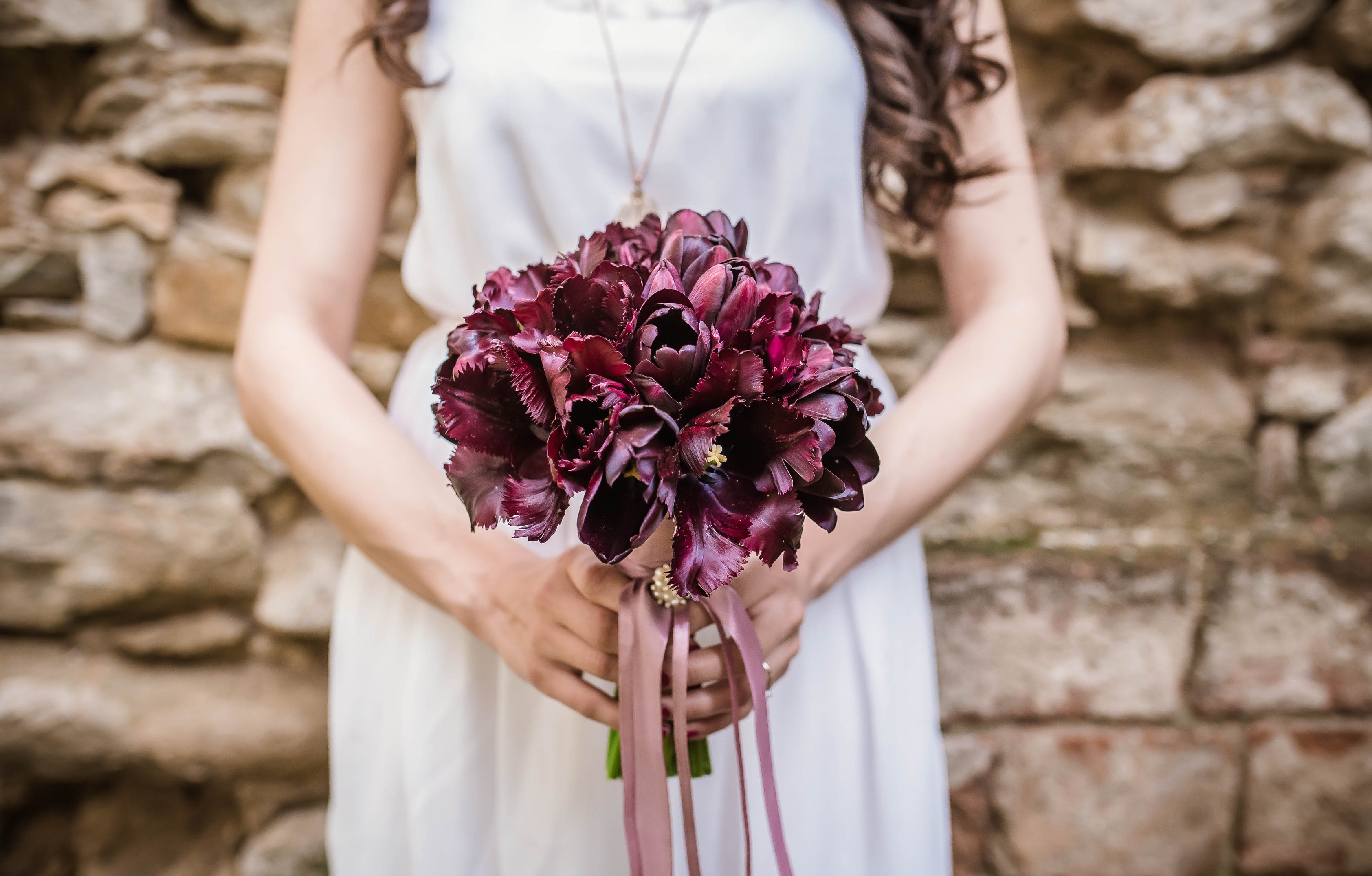 woman in white dress holding bouquet of flowers