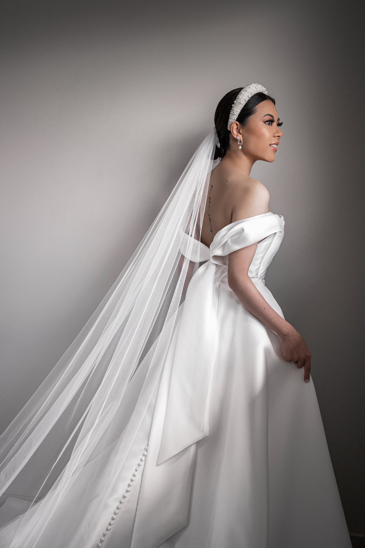 woman wearing wedding dress with veil attached to headband