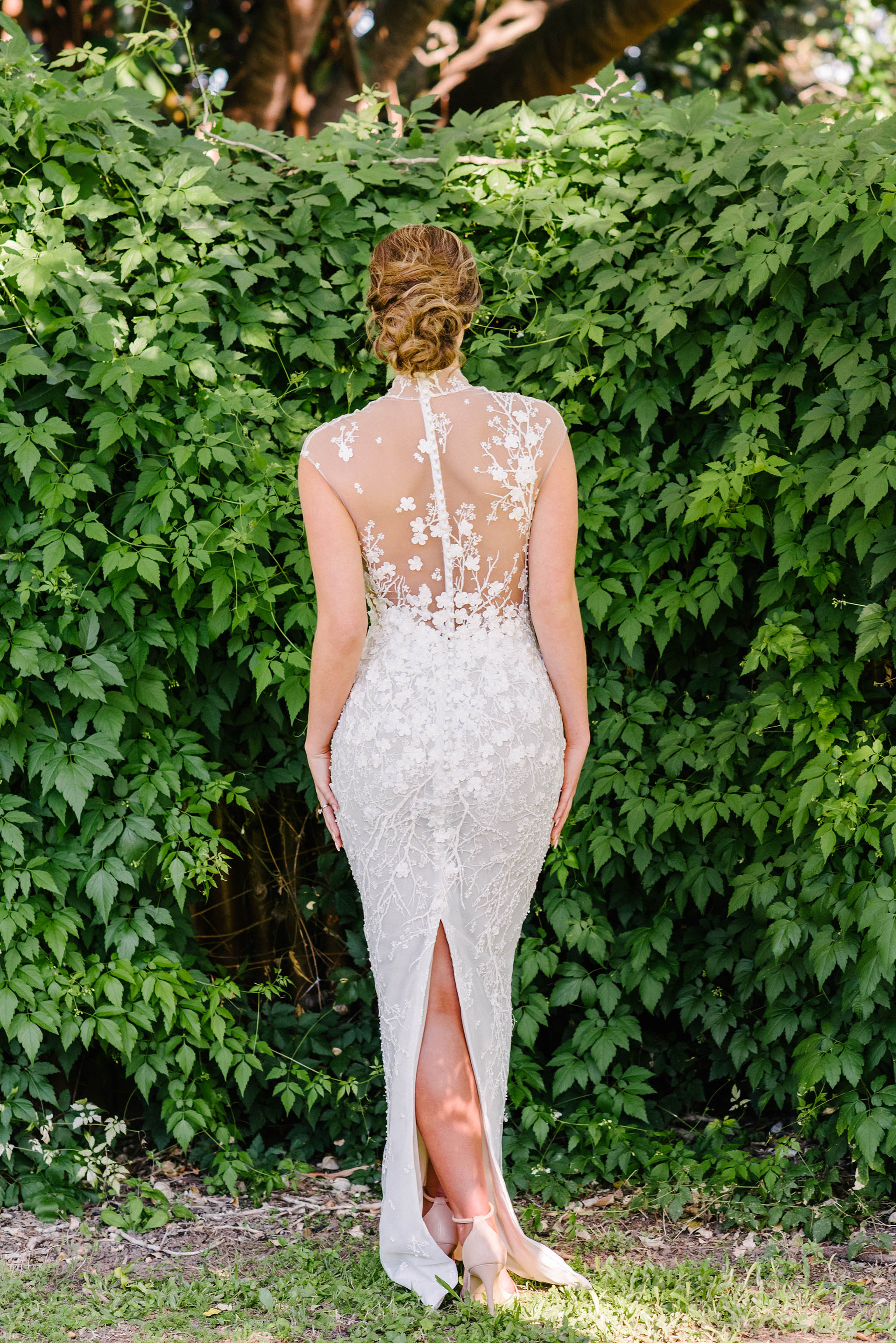 bride facing trees in wedding dress with illusion lace
