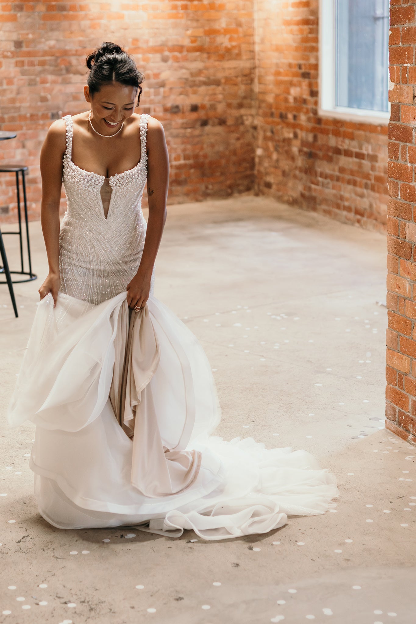 bride holding pearl embellished wedding gown