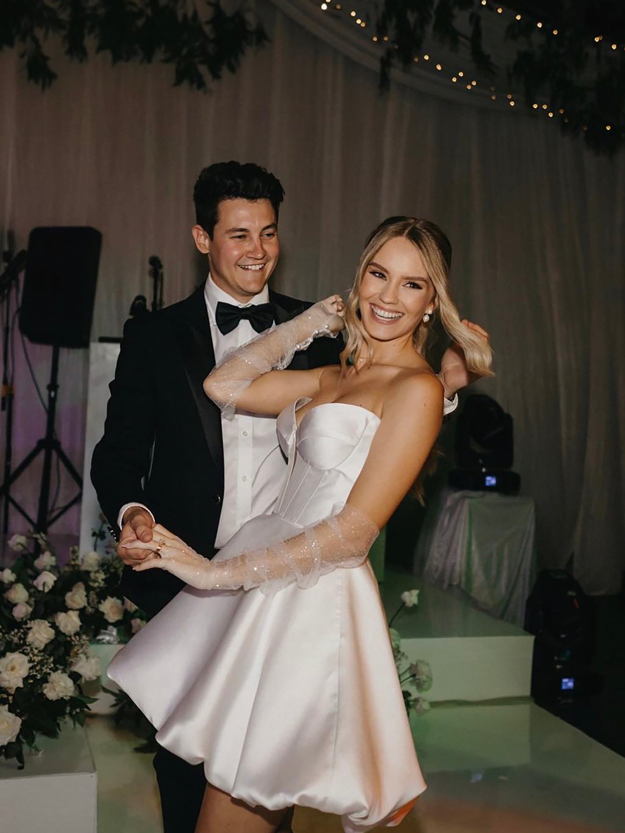 bride in mikado mini wedding dress dancing with groom in suit