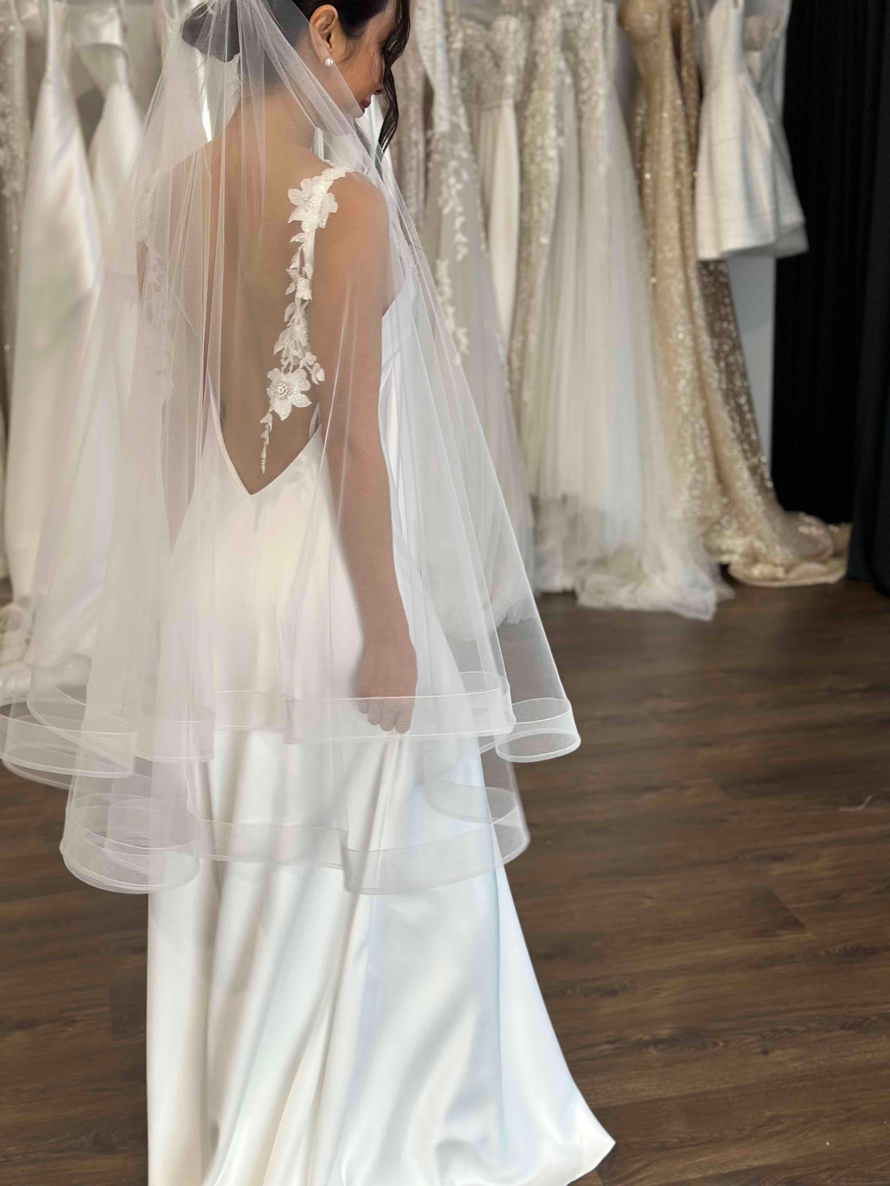 bride in white tulle veil with ivory slip gown featuring floral lace straps