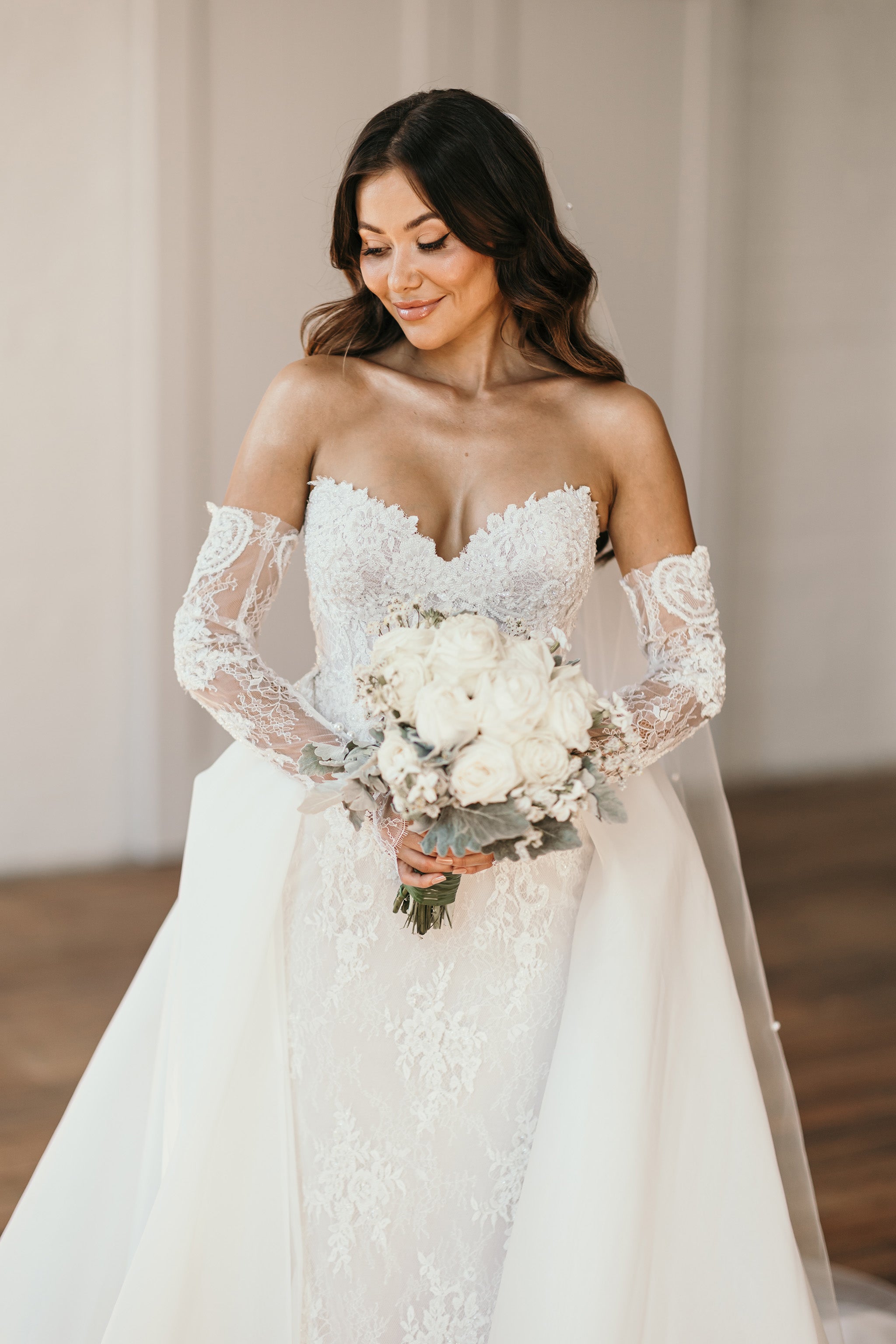 bride posing for photos in wedding gown and overskirt