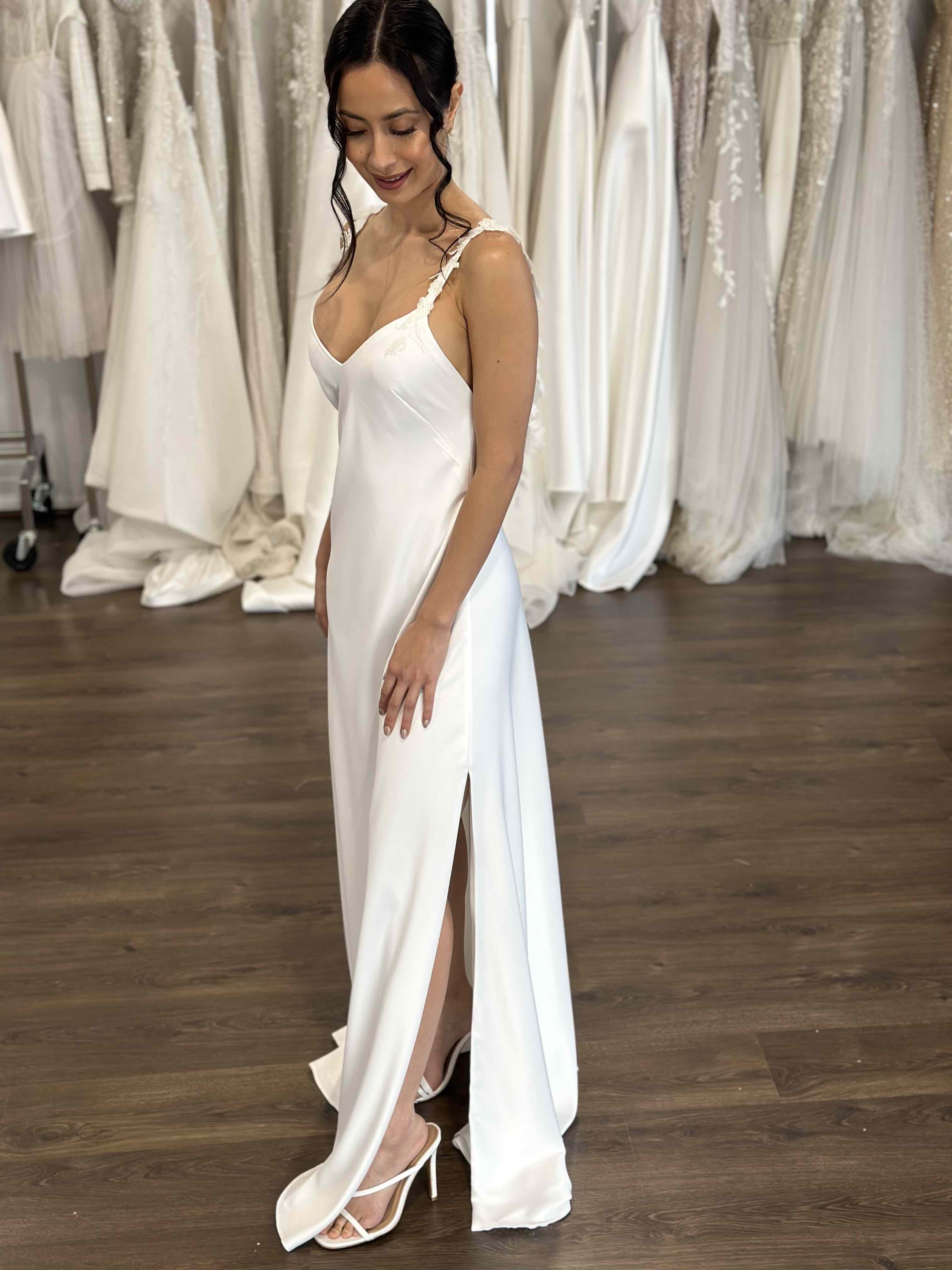 bride wearing slip wedding reception dress with floral lace straps and skirt split