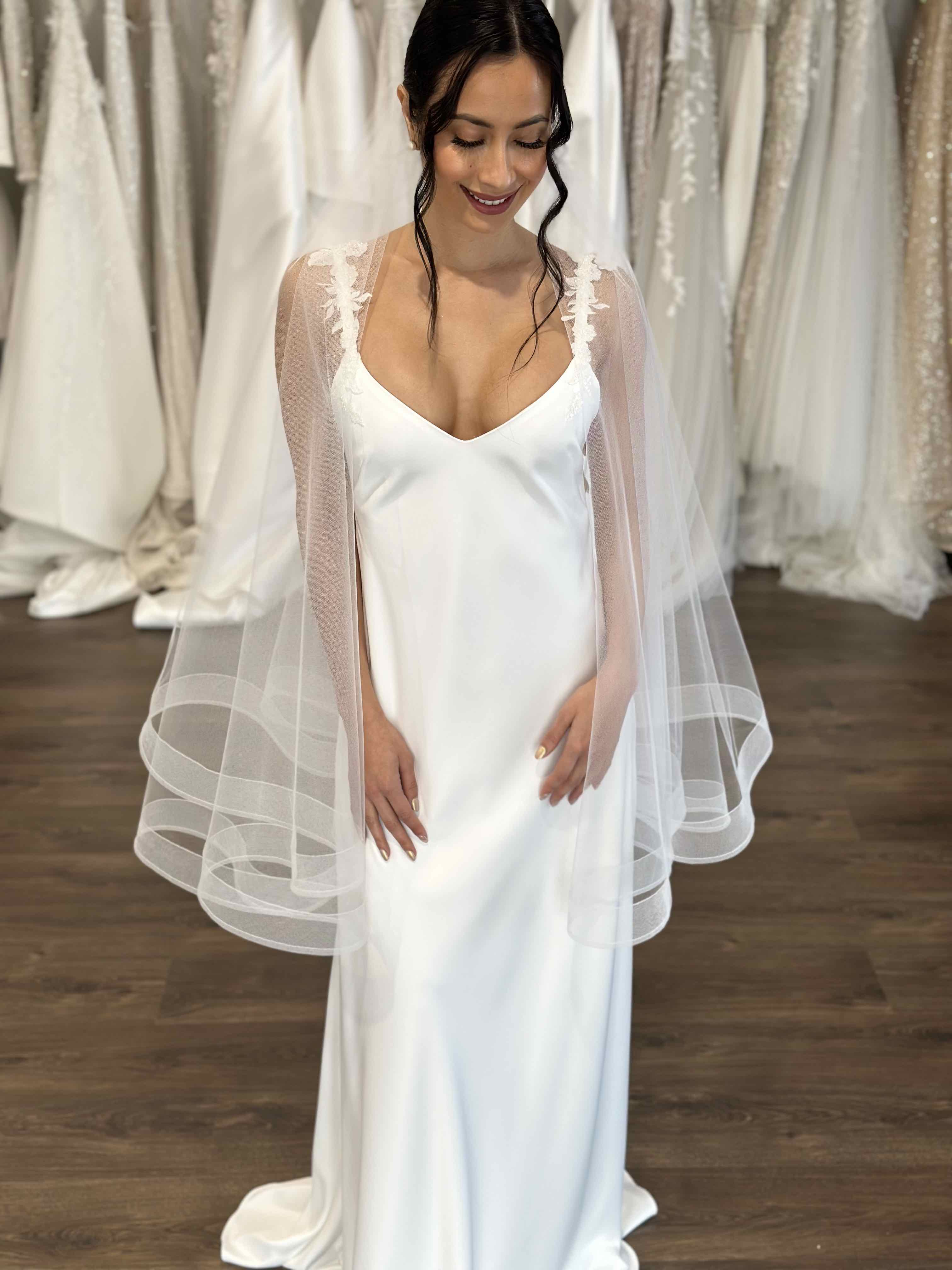 bride with black hair smiling wearing a tulle veil and white slip dress with floral straps