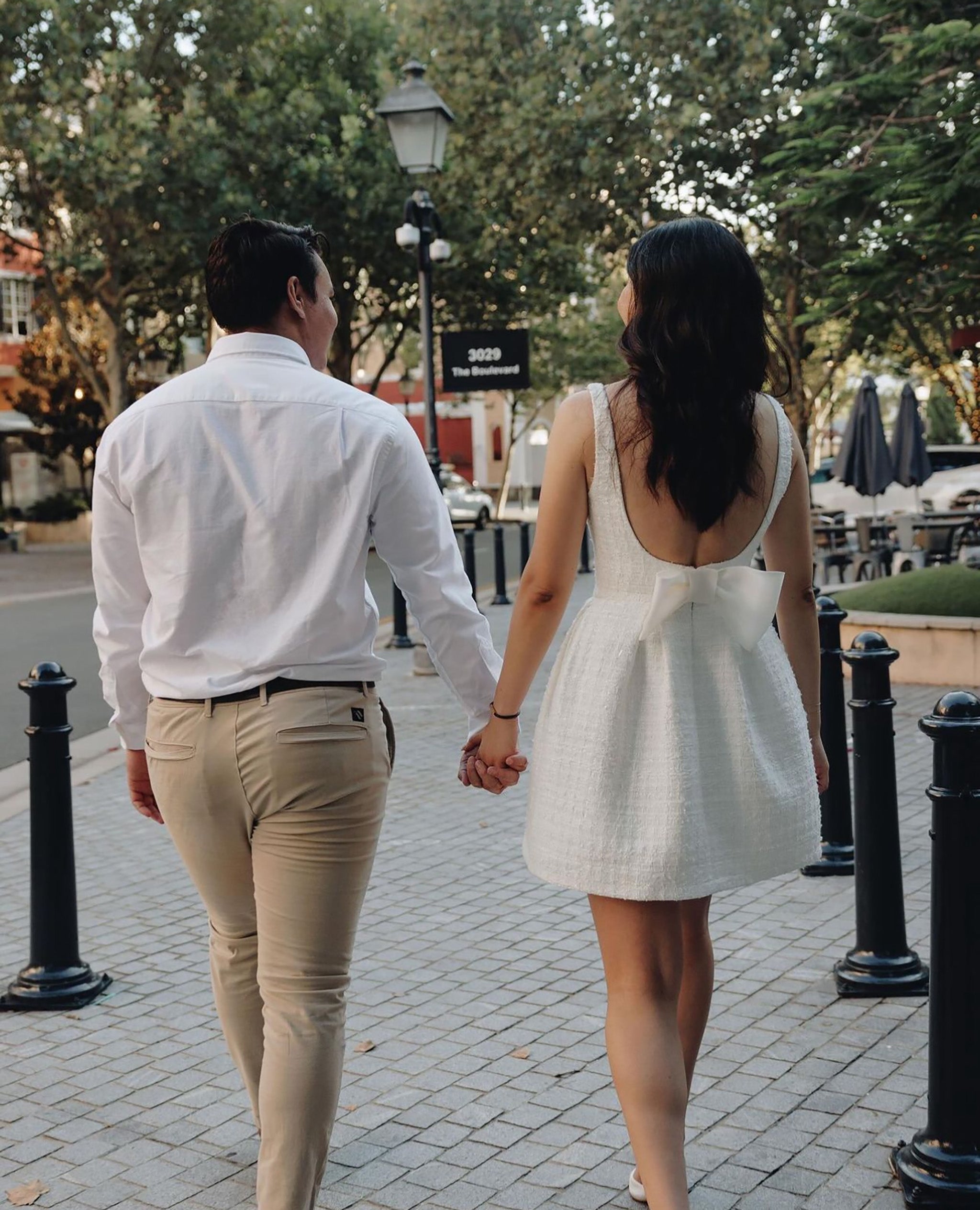 couple walking hand in hand down city street