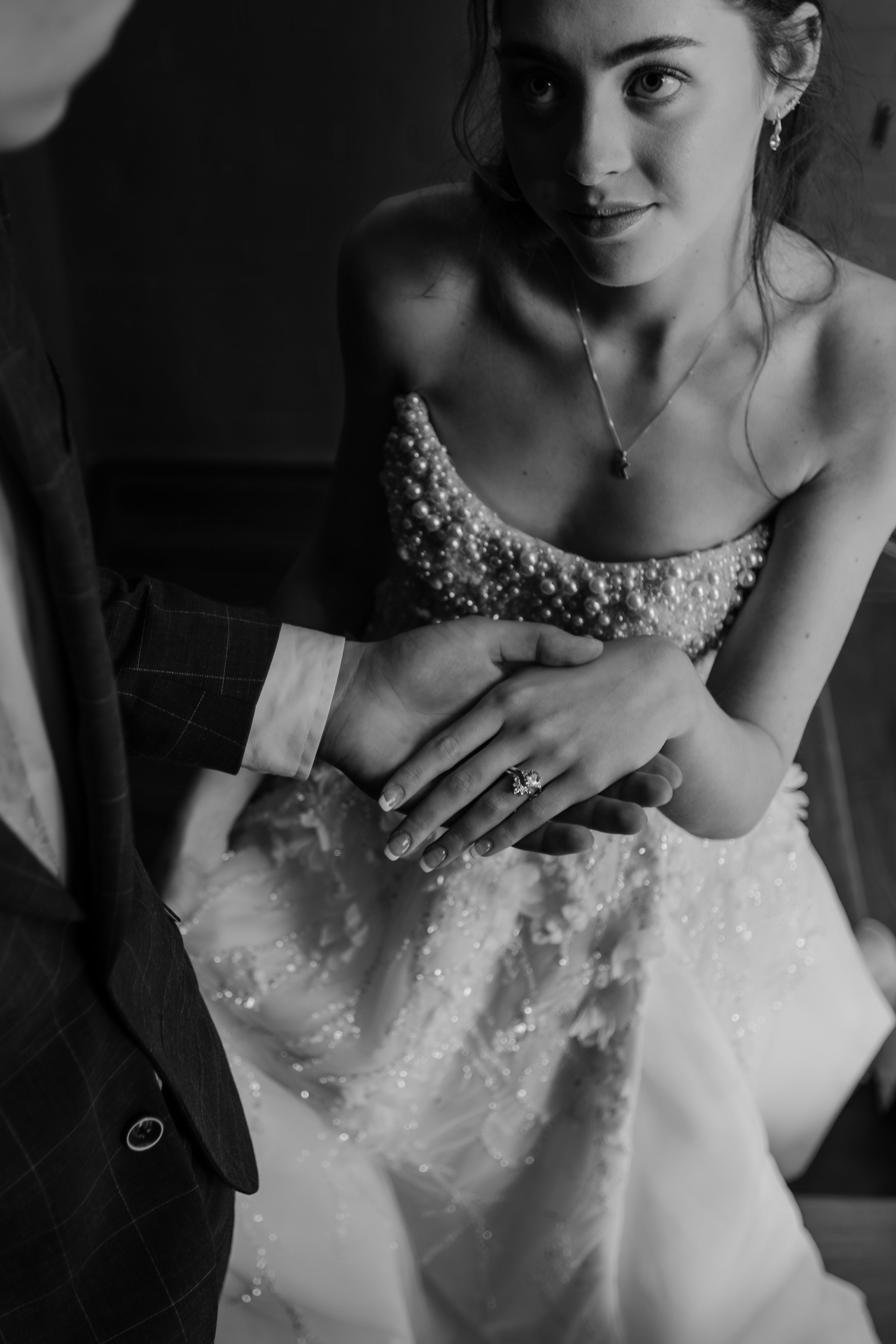 groom cuddling his bride on stairway taking her hand