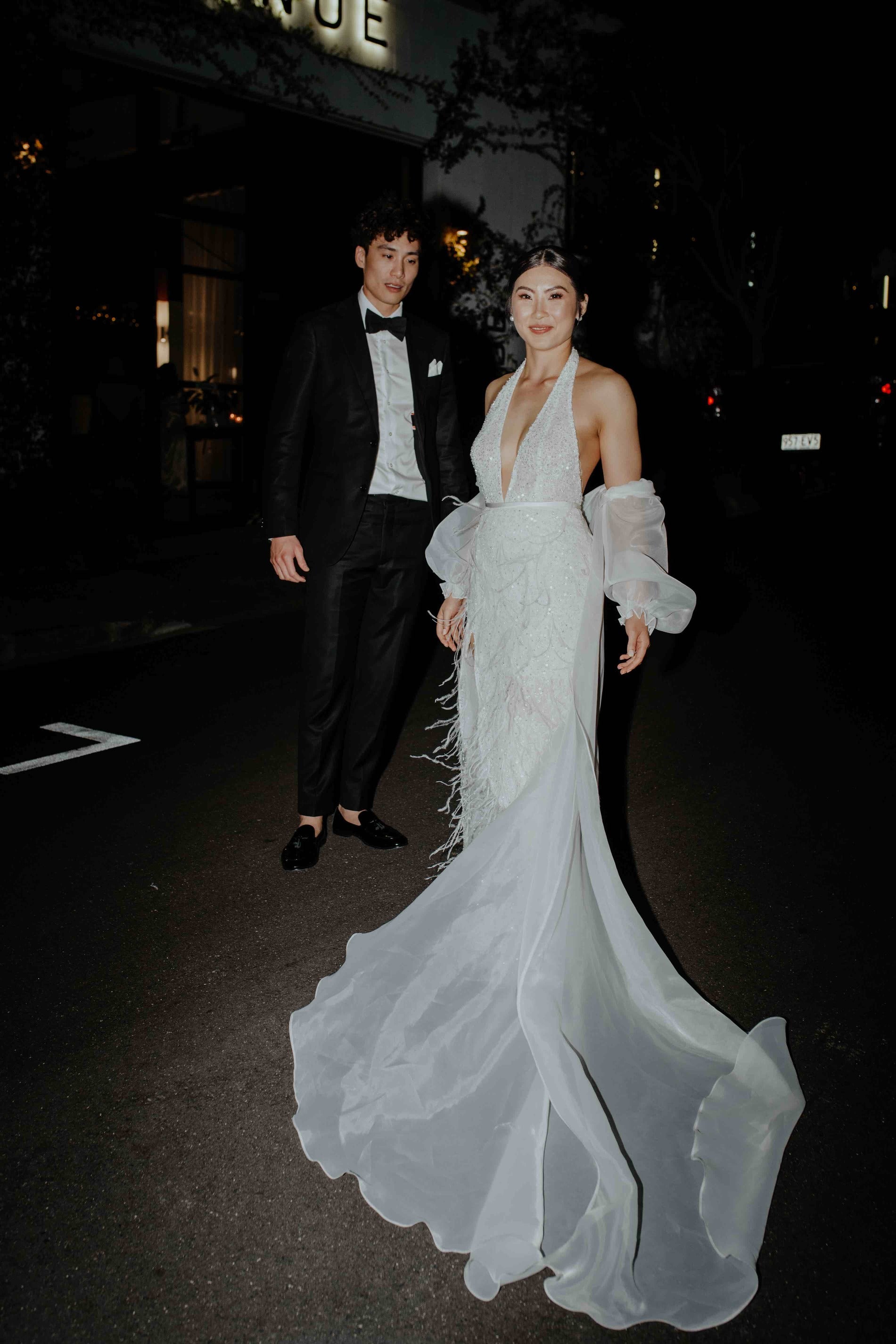 husband and wife outside restaurant in wedding attire