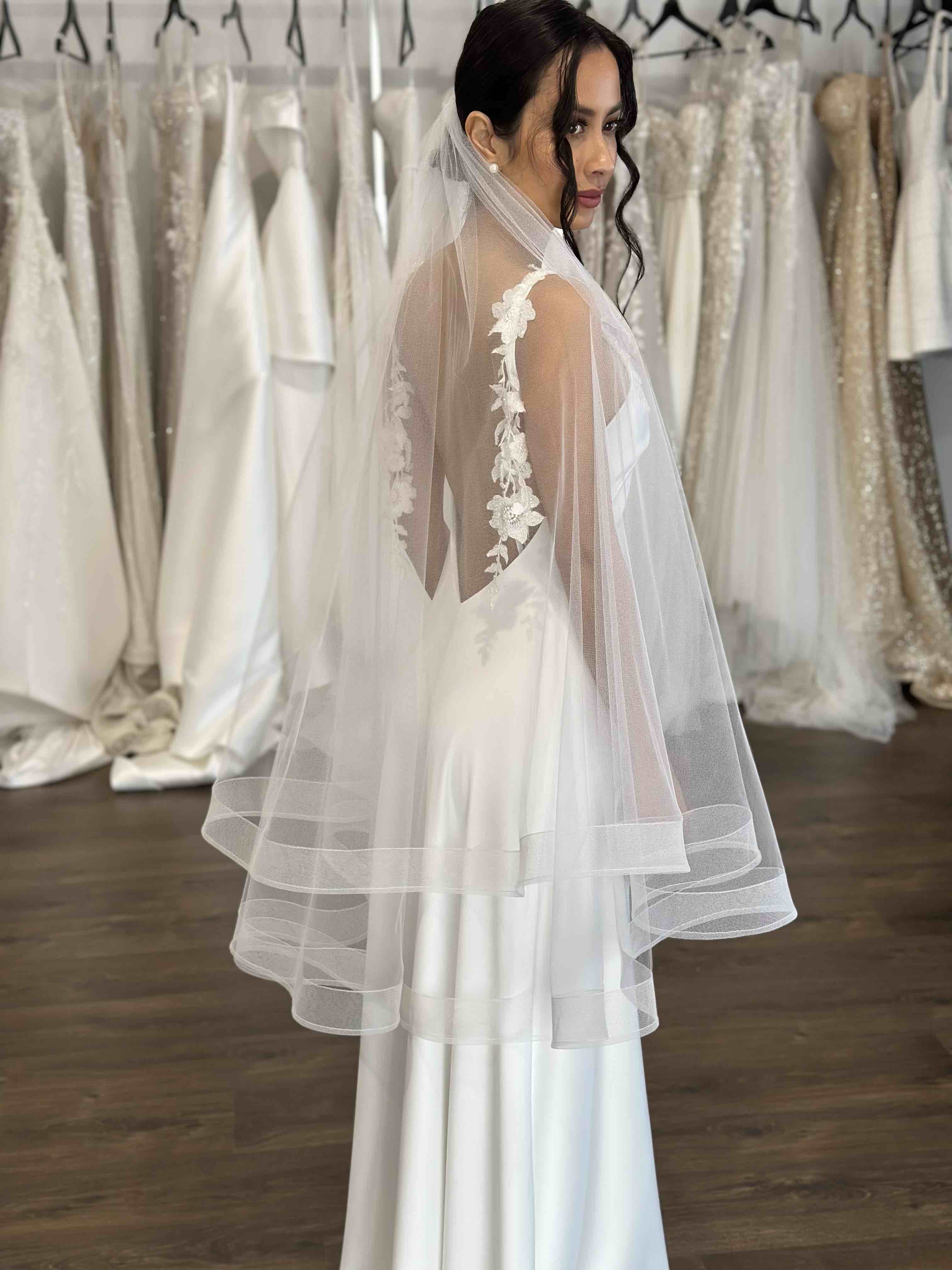 model in white tulle veil and wedding gown