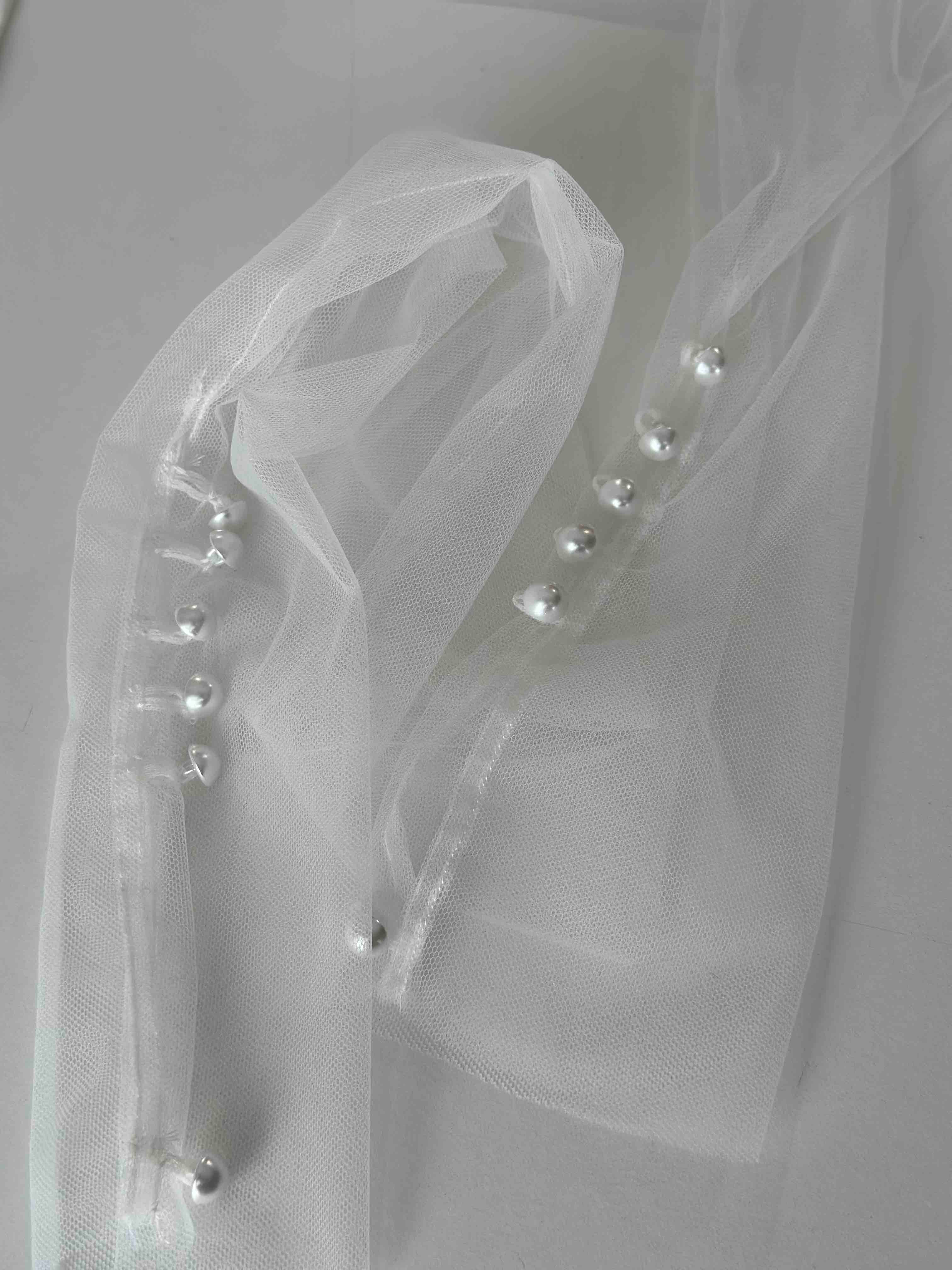 pearl buttons sewn onto tulle bridal gloves