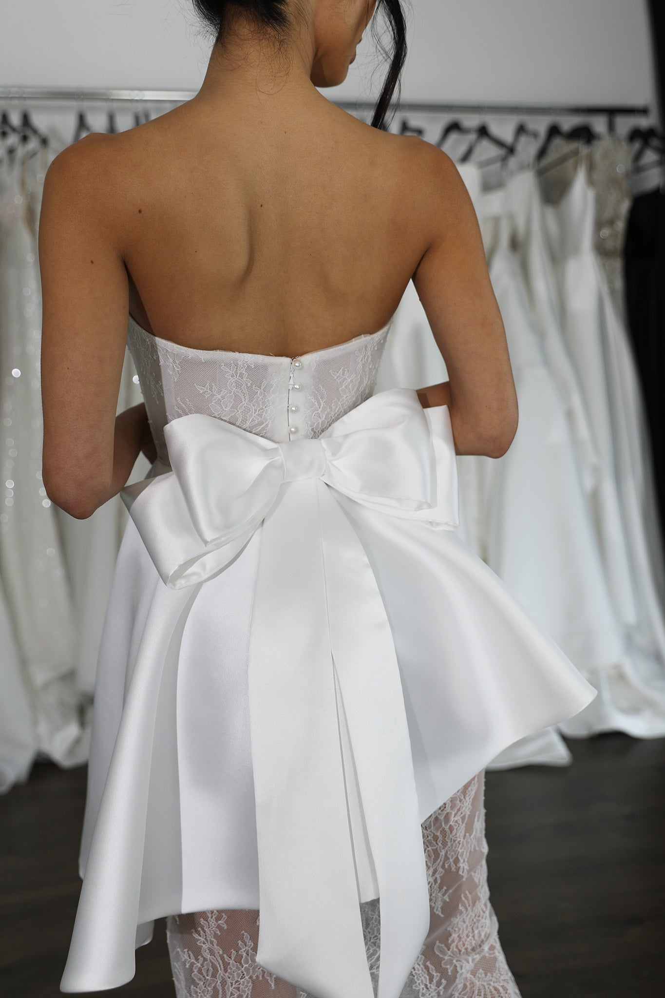 white double bow attached to wedding dress
