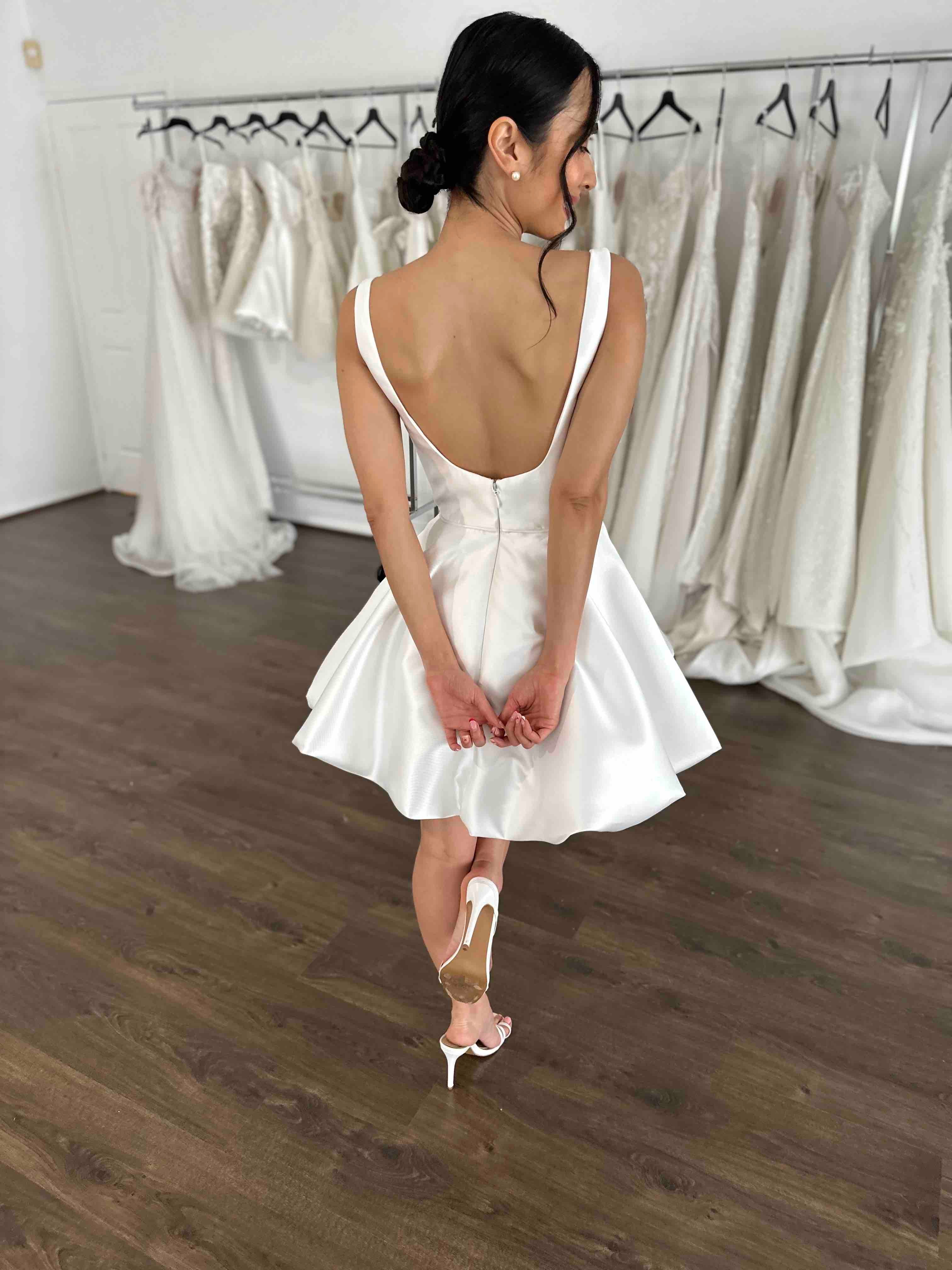 woman wearing low back bubble hem mini bridal second dress