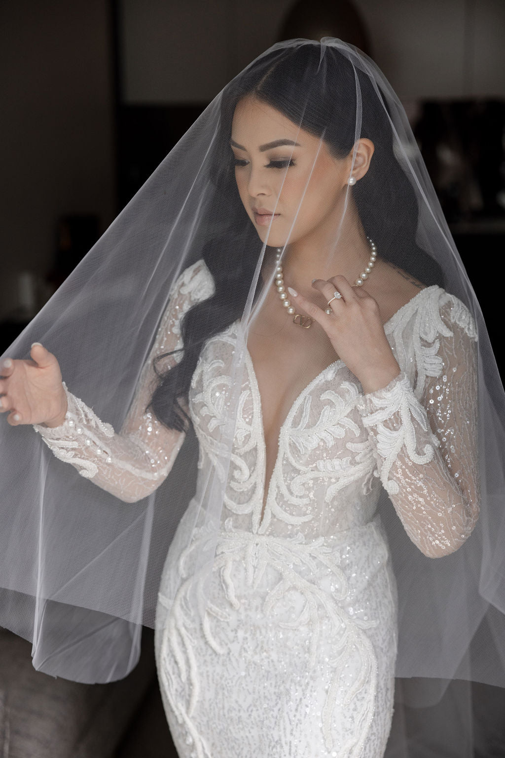 bride with veil covering her face in wedding gown