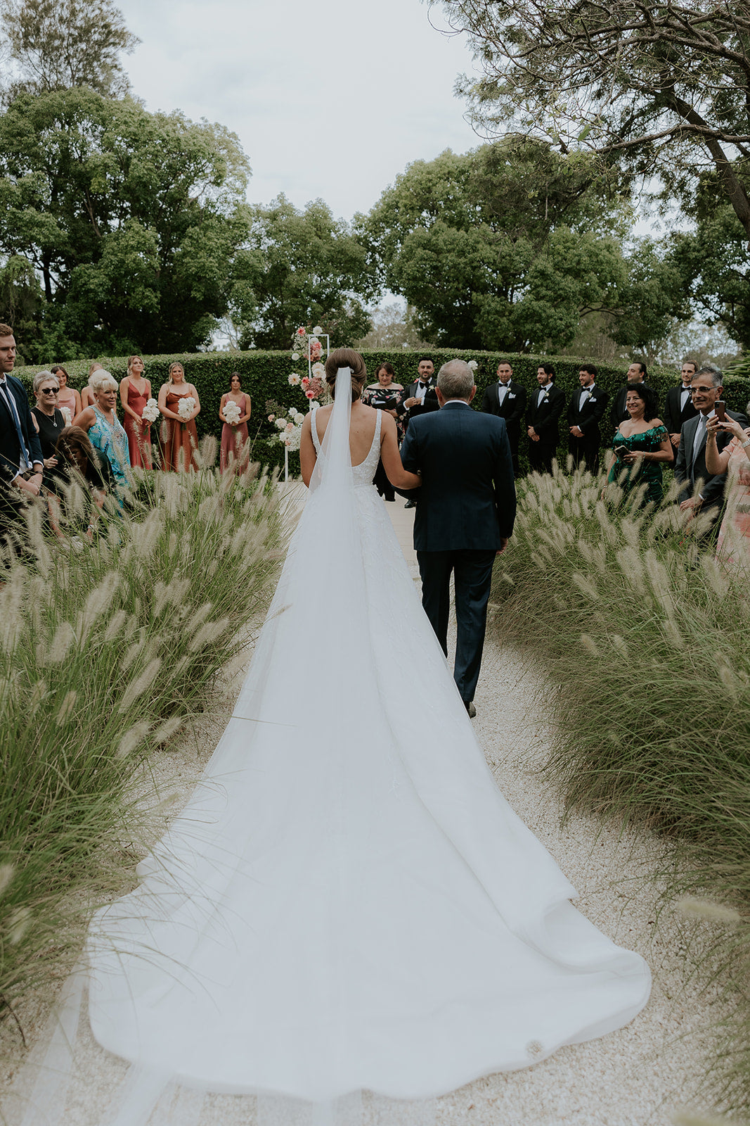 husband and wife walking towards wedding guests