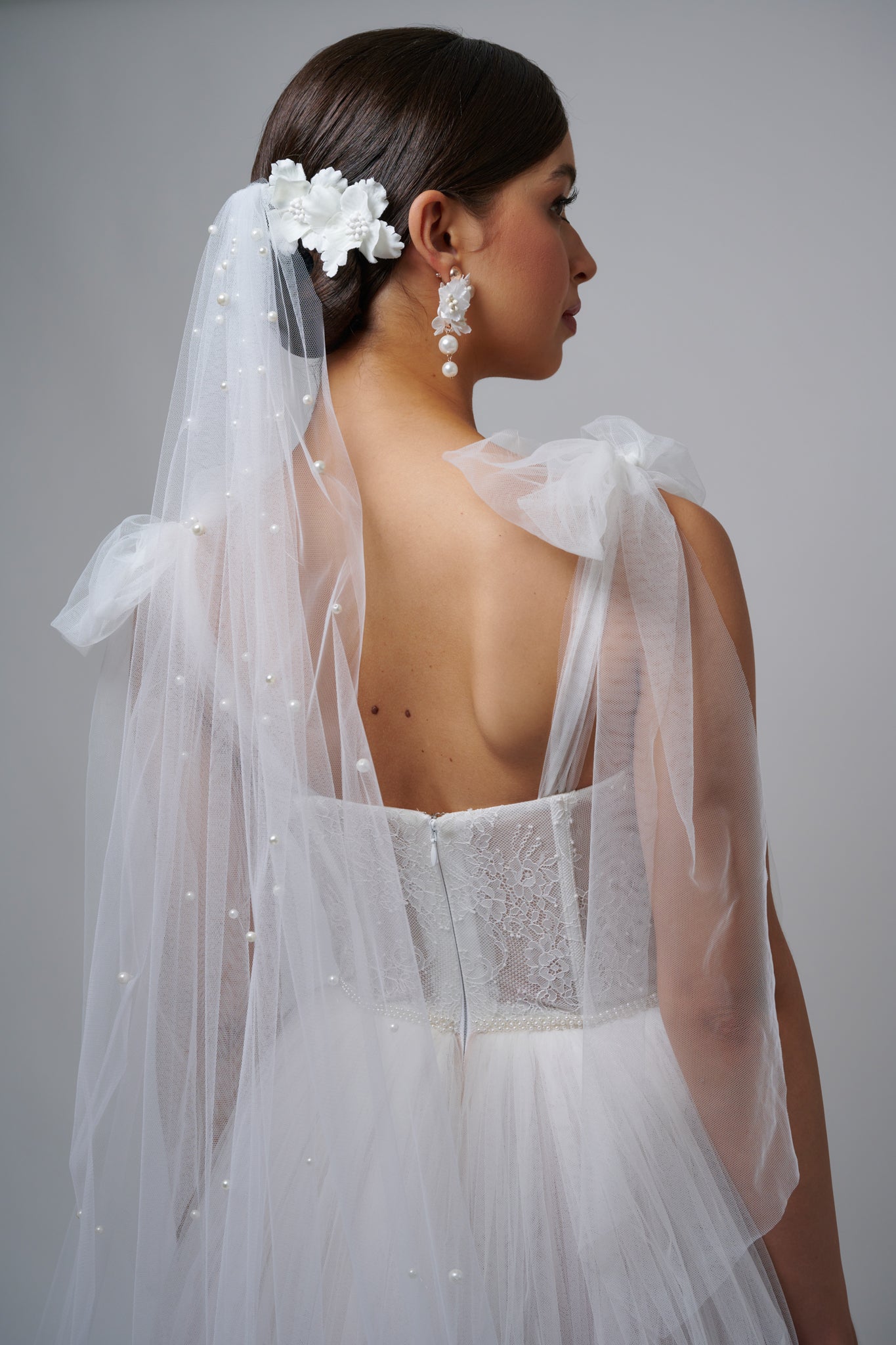 pearl tulle bridal veil in brunette womans hair on her wedding day