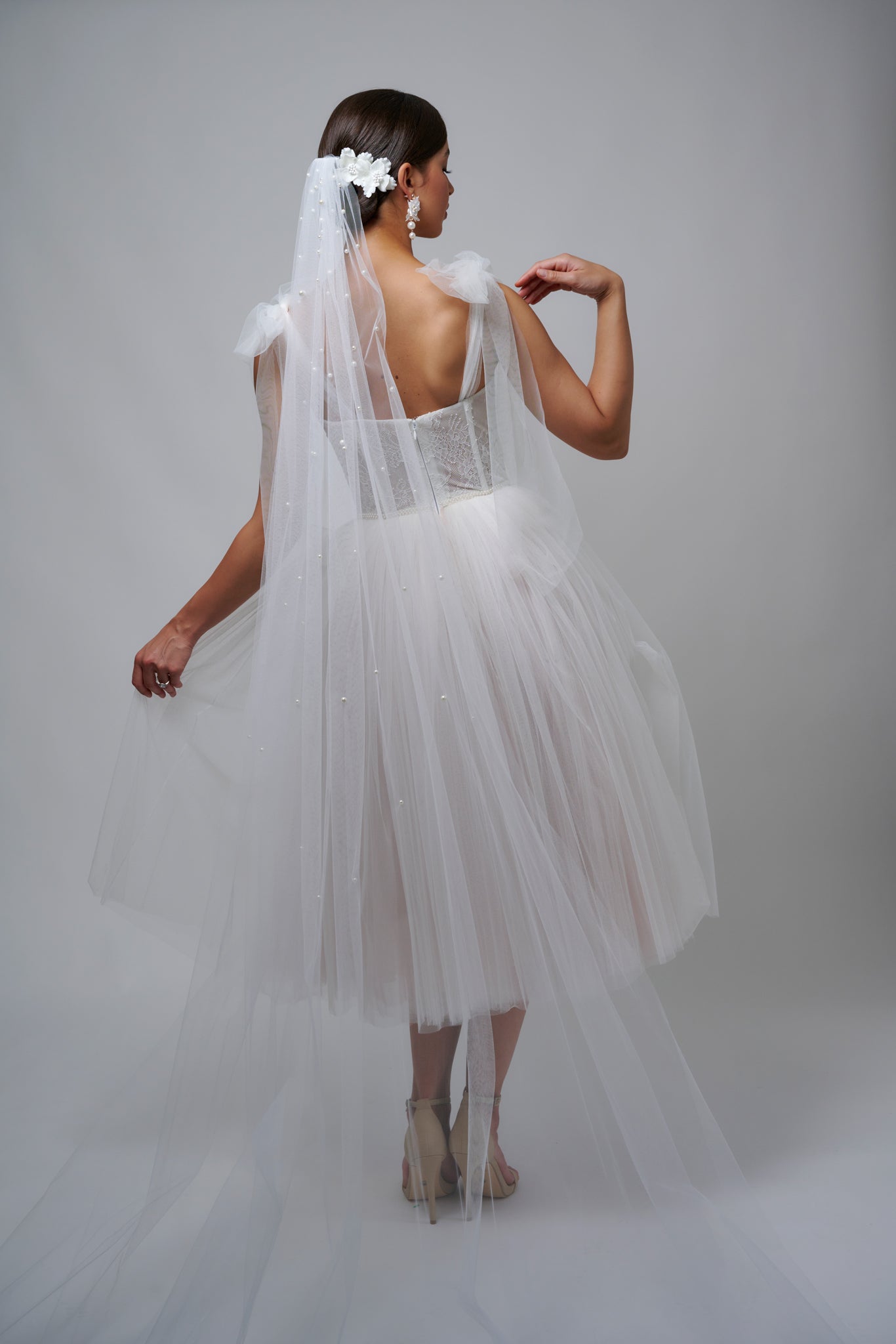 woman wearing pearl bridal veil with tulle wedding dress and nude heels