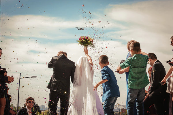 bride and groom raising bouquet on wedding day