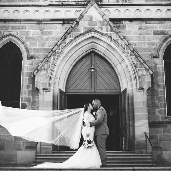 bride kissing husband on church steps