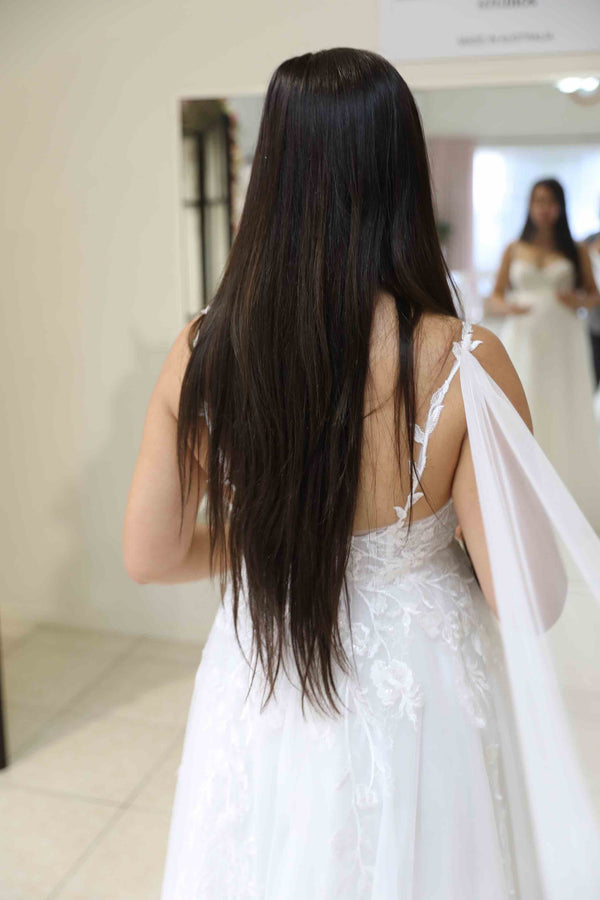bride looking at herself in the mirror in her wedding dress