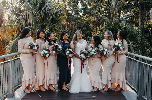 bride posing for photos in a line with bridesmaids