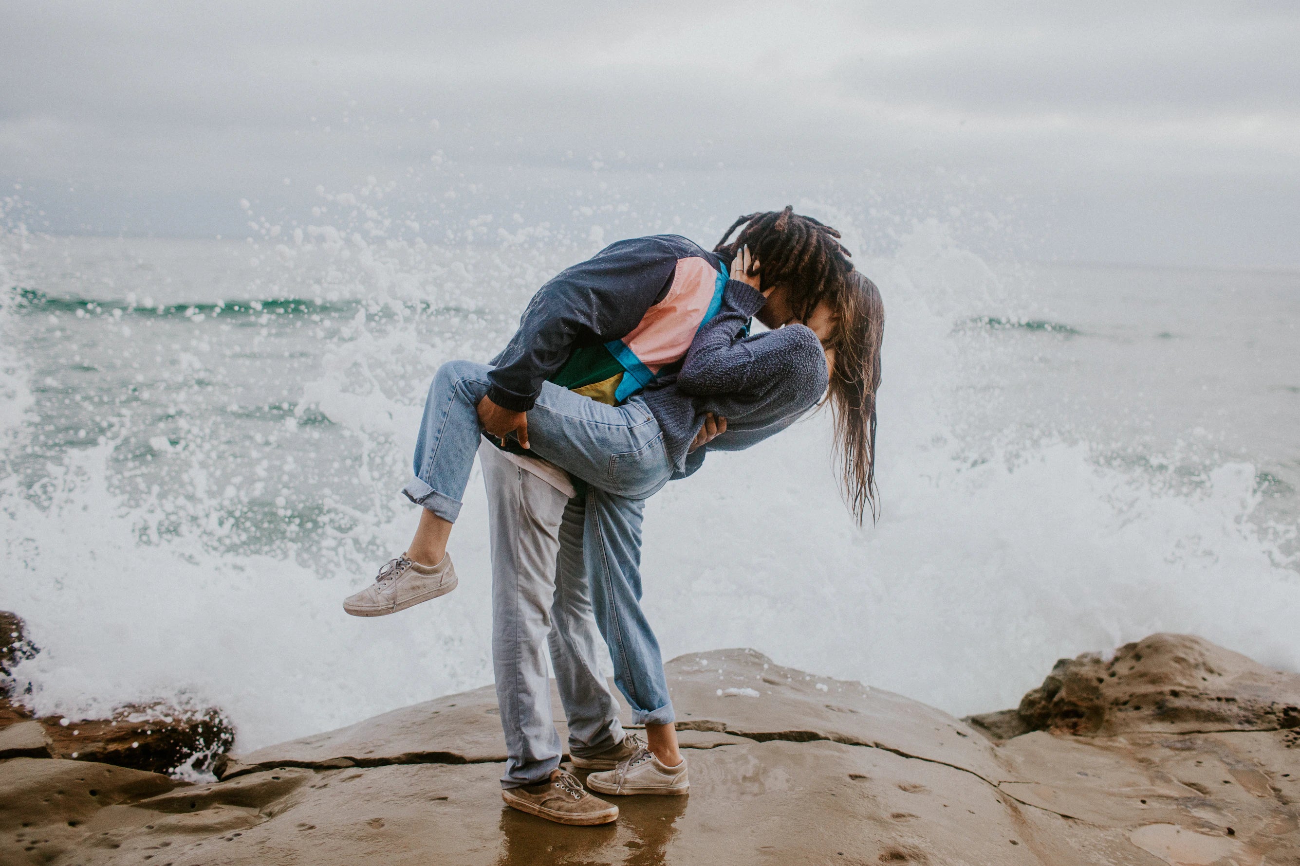 couple kissing in front of ocean