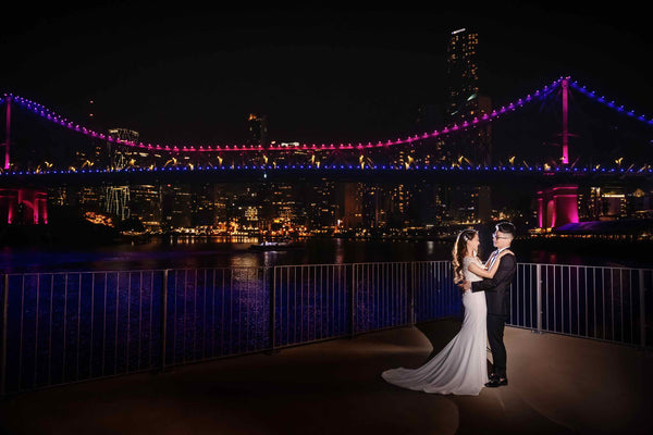 husband and wife hugging-on their wedding day in front of the Brisbane city skyline