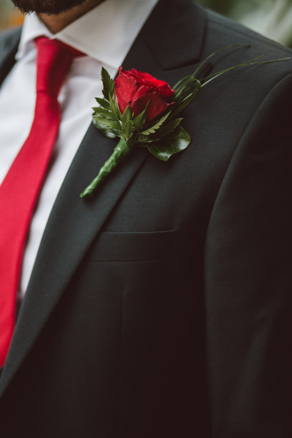 mens suit with rose flower on the collar and red tie