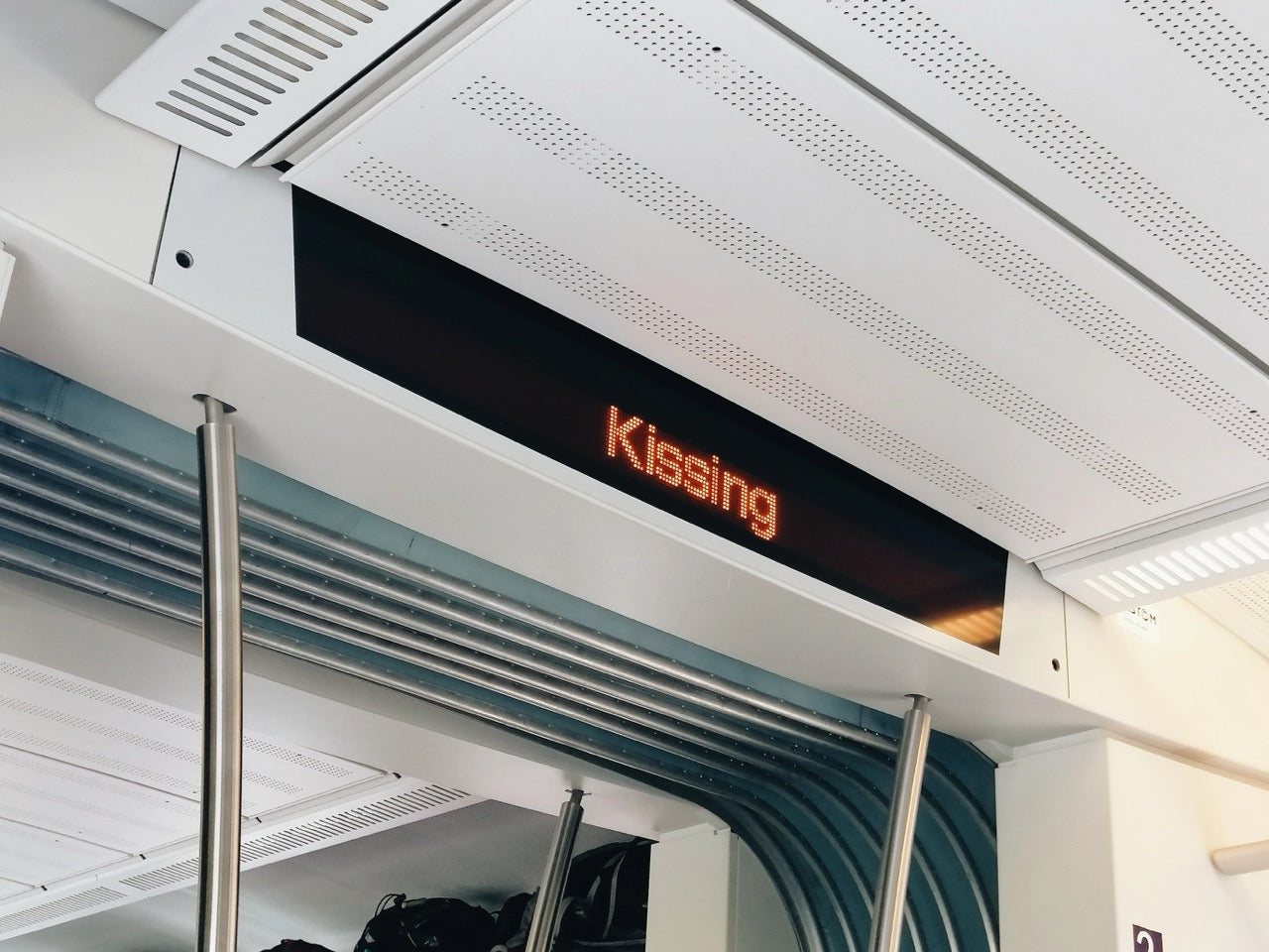 neon sign with the word kissing