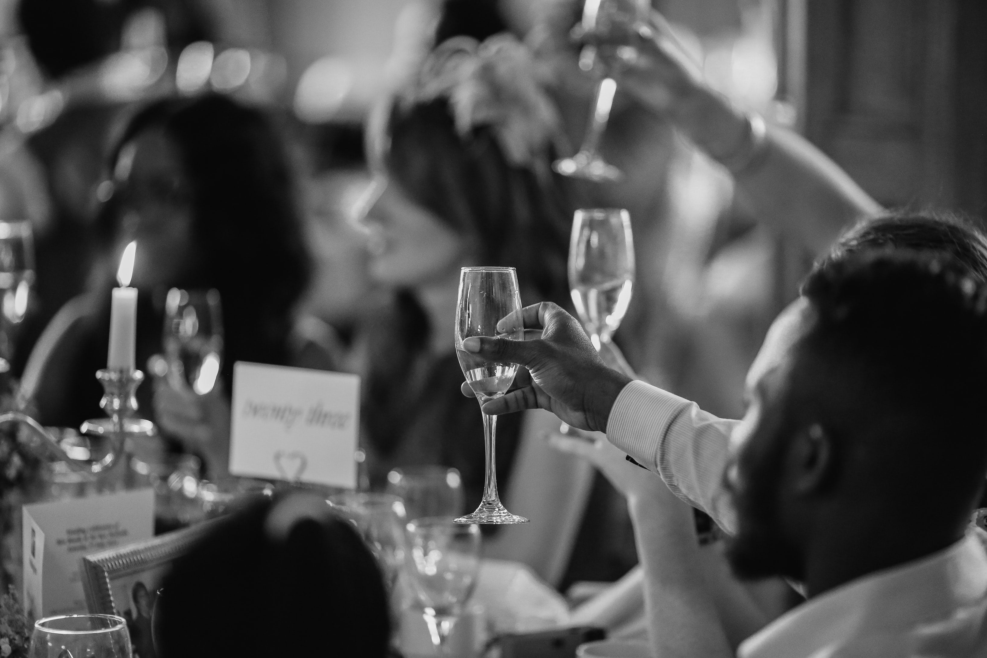 people raising wine glasses to toast at a wedding