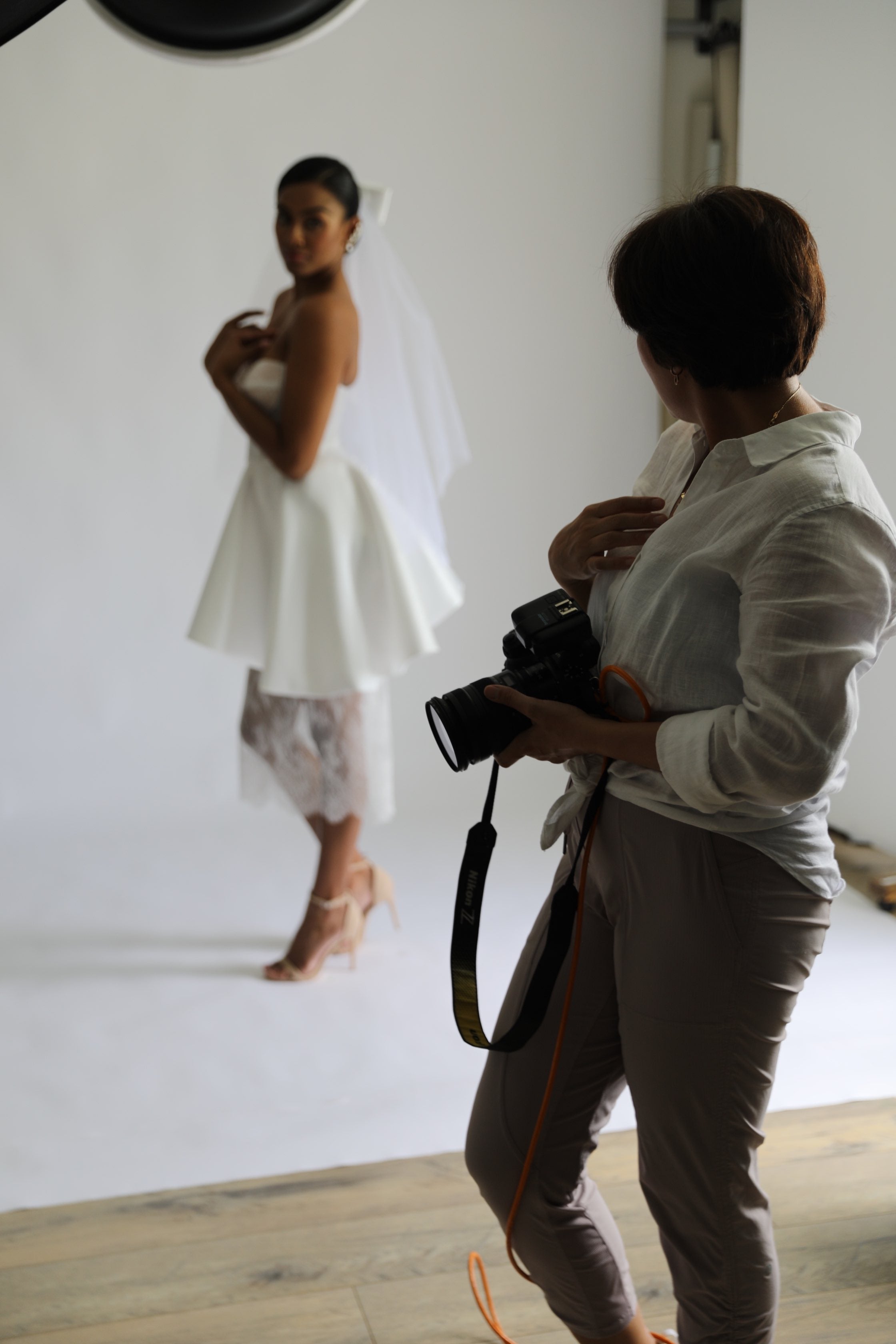 photographer teaching model in wedding dress how to pose