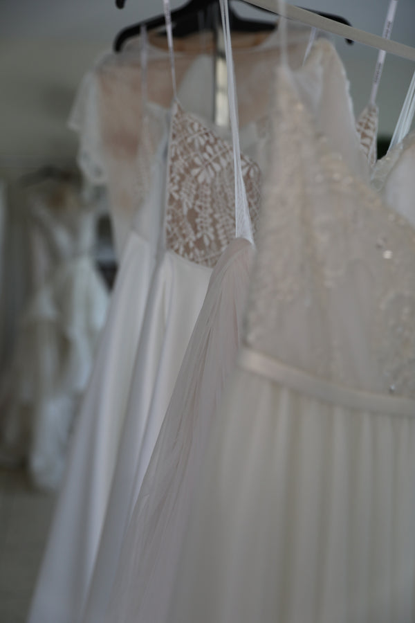 rack full of lace and tulle wedding dresses