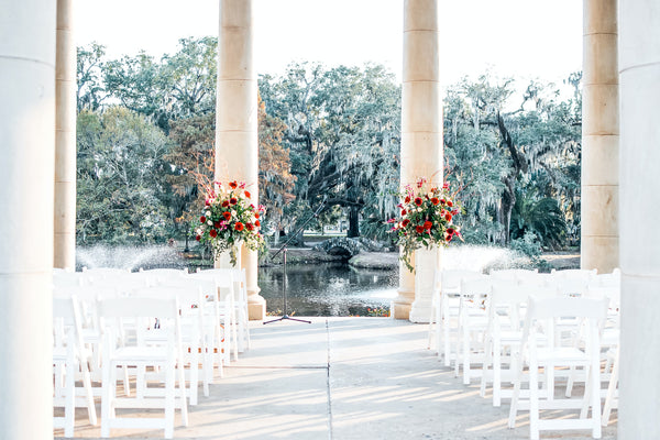 wedding aisle with white seats and bouquets overlooking pond and trees