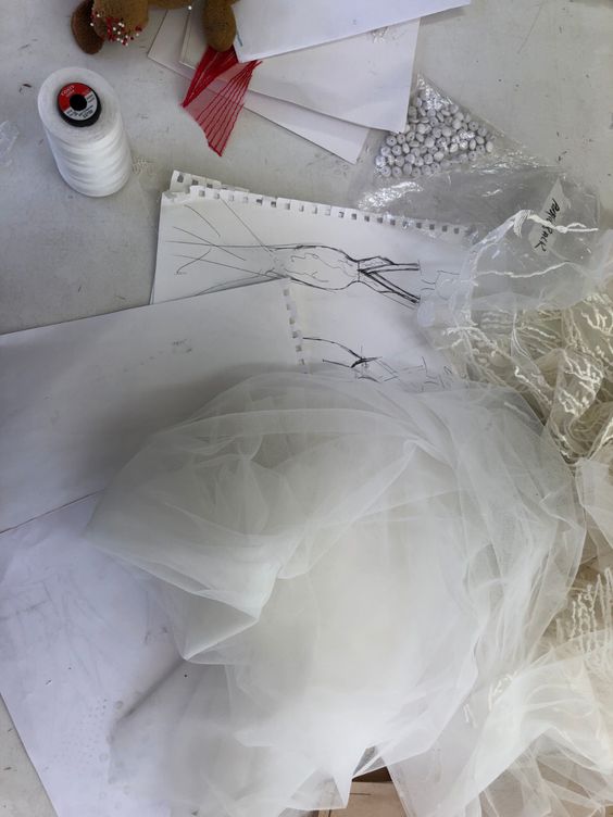 wedding dress sketches on table with fabrics and paper