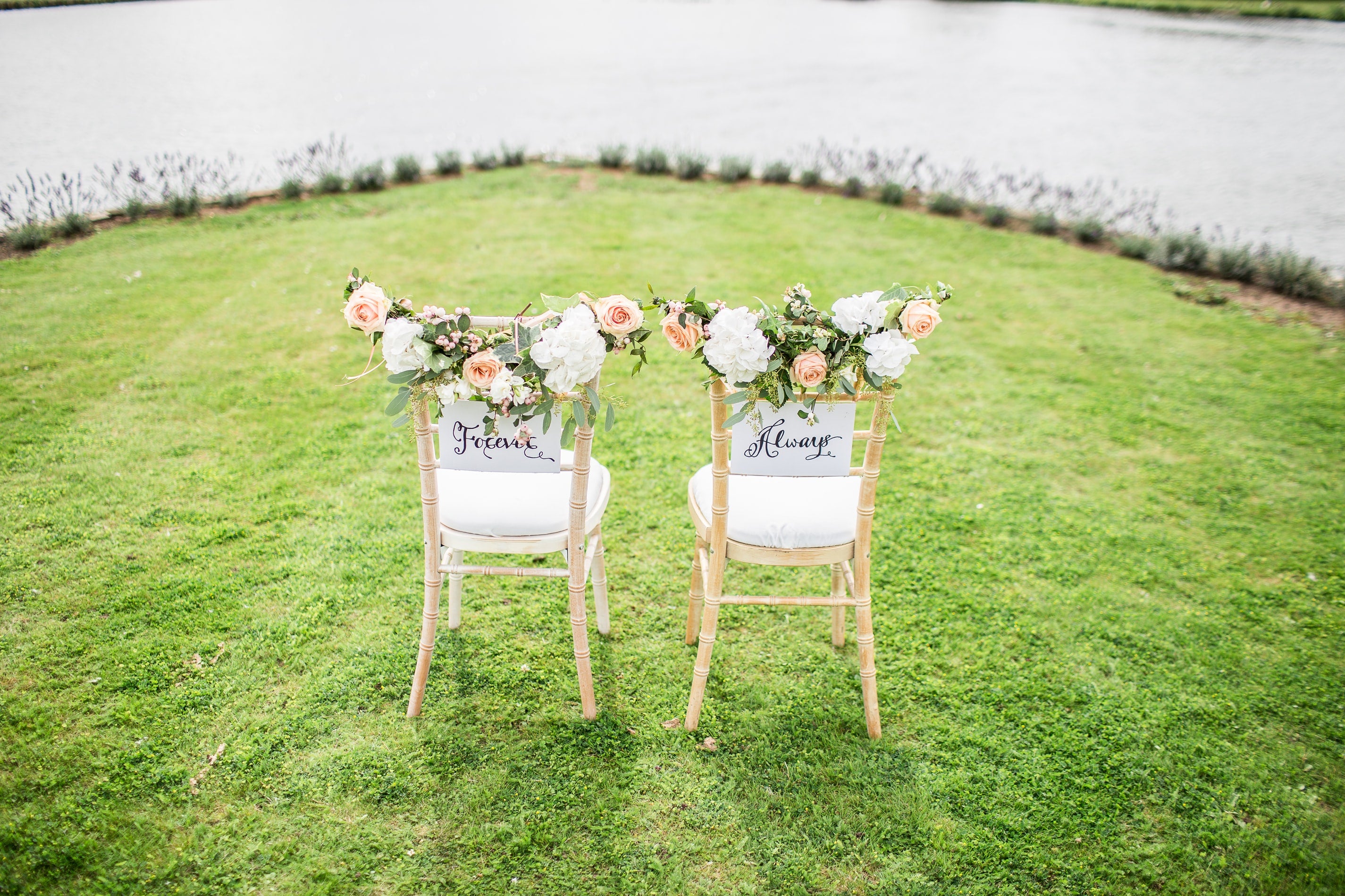 wedding seating for bride and groom covered in flowers on grass