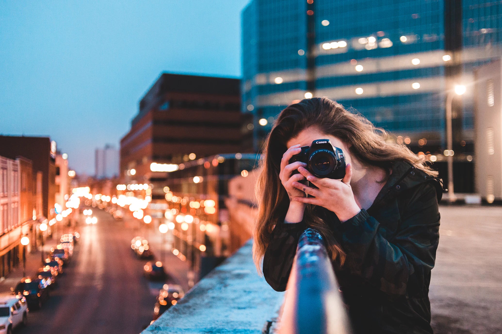 woman in front of cityscape with camera