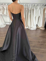 black strapless formal dress on woman's body in store