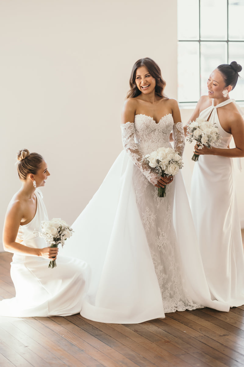 bride and bridesmaid wearing gowns on wedding day