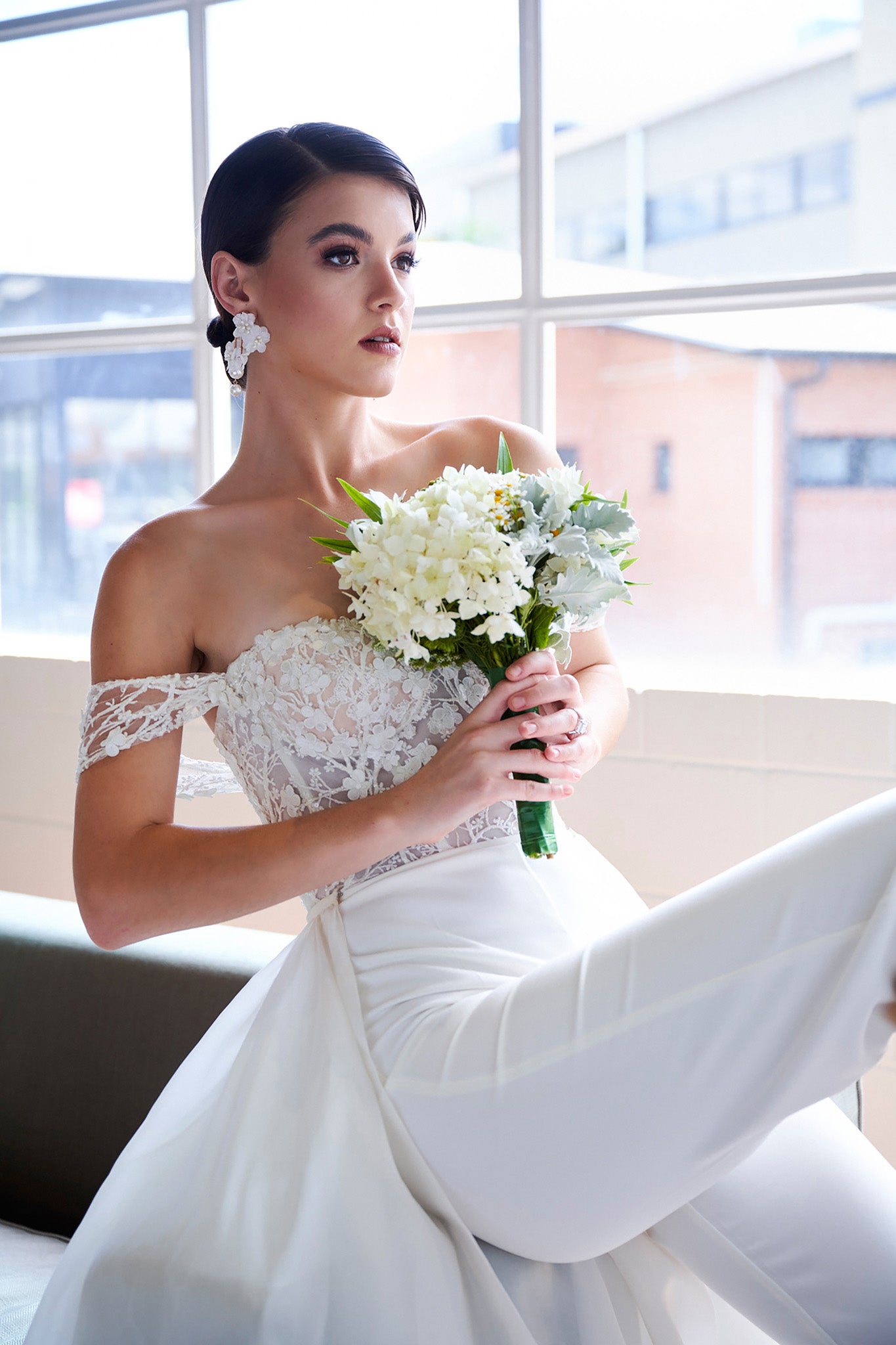 bride holding flowers in bridal pant suit