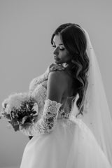 bride in wedding dress with gloves holding bouquet