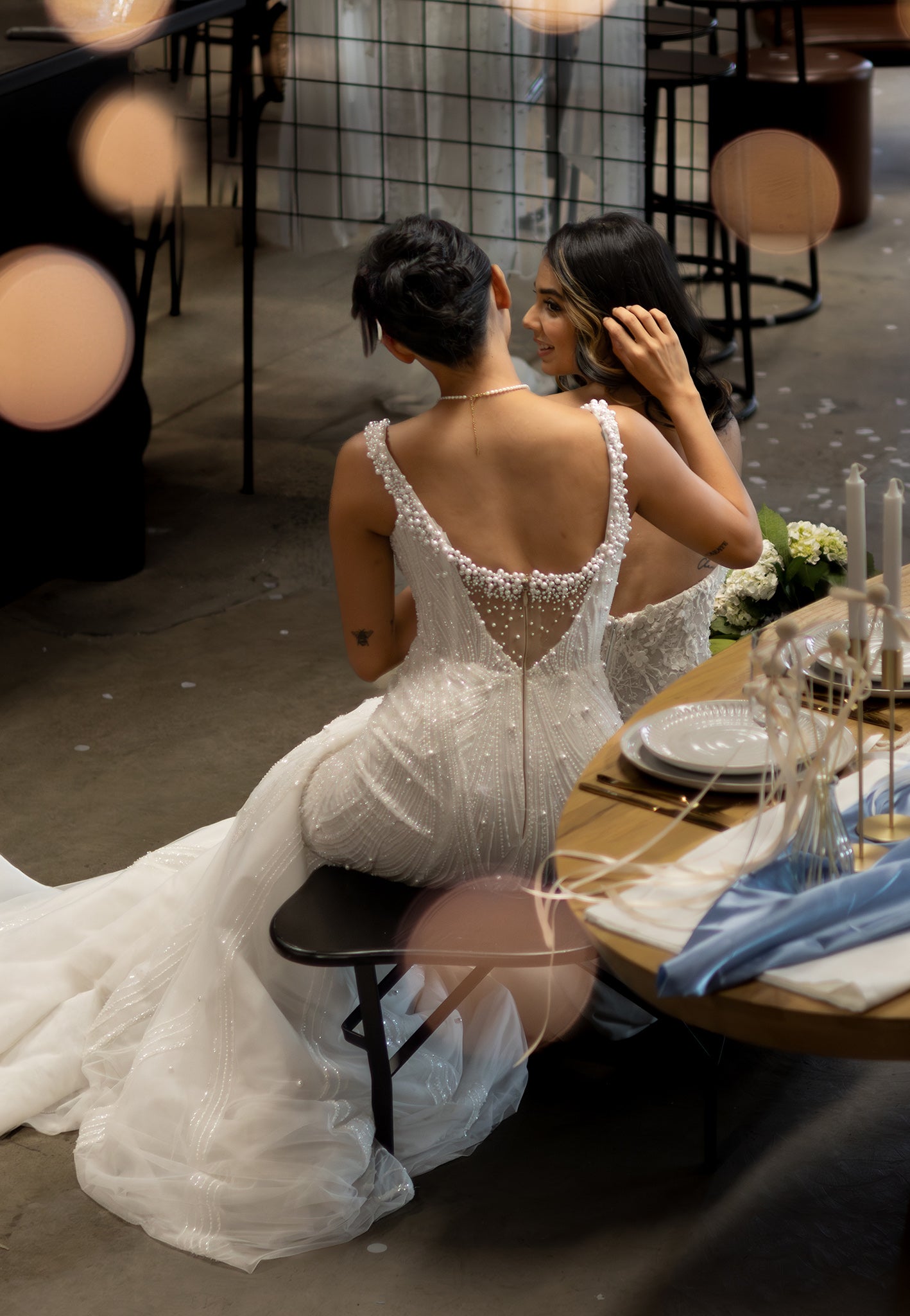 bride sitting on table in pearl beaded gown