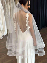 bride smiling wearing white slip dress and tulle veil