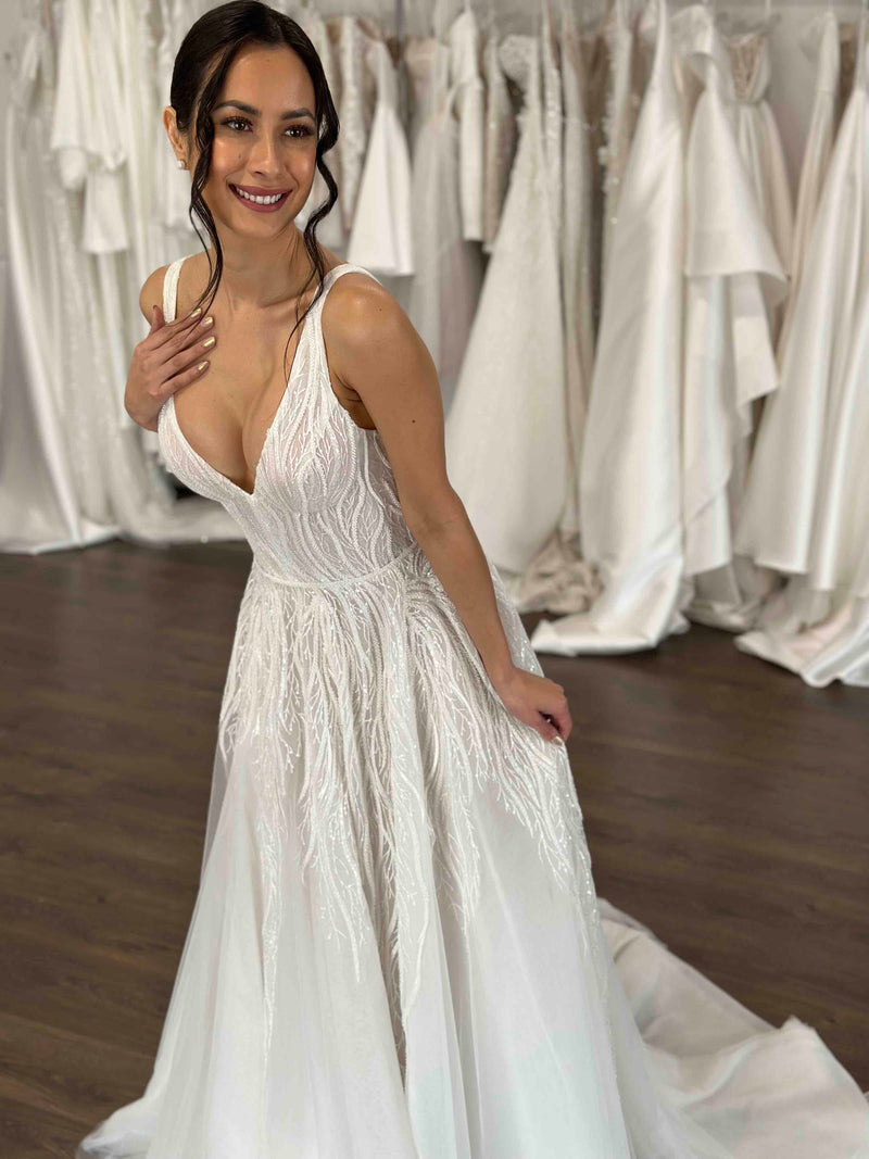 bride smiling while she poses in her wedding gown