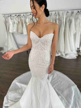 bride smiling with arm out in wedding dress